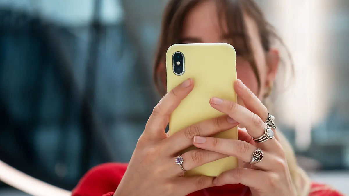 Ein junge Frau kommuniziert mit ihrem Mobiltelefon. Aufgenommen am 05.07.203 in Berlin