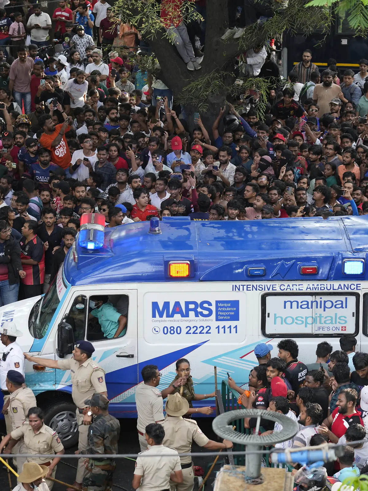 Ein Krankenwagen bahnt sich den Weg durch die Fan-Massen am Stadion. 