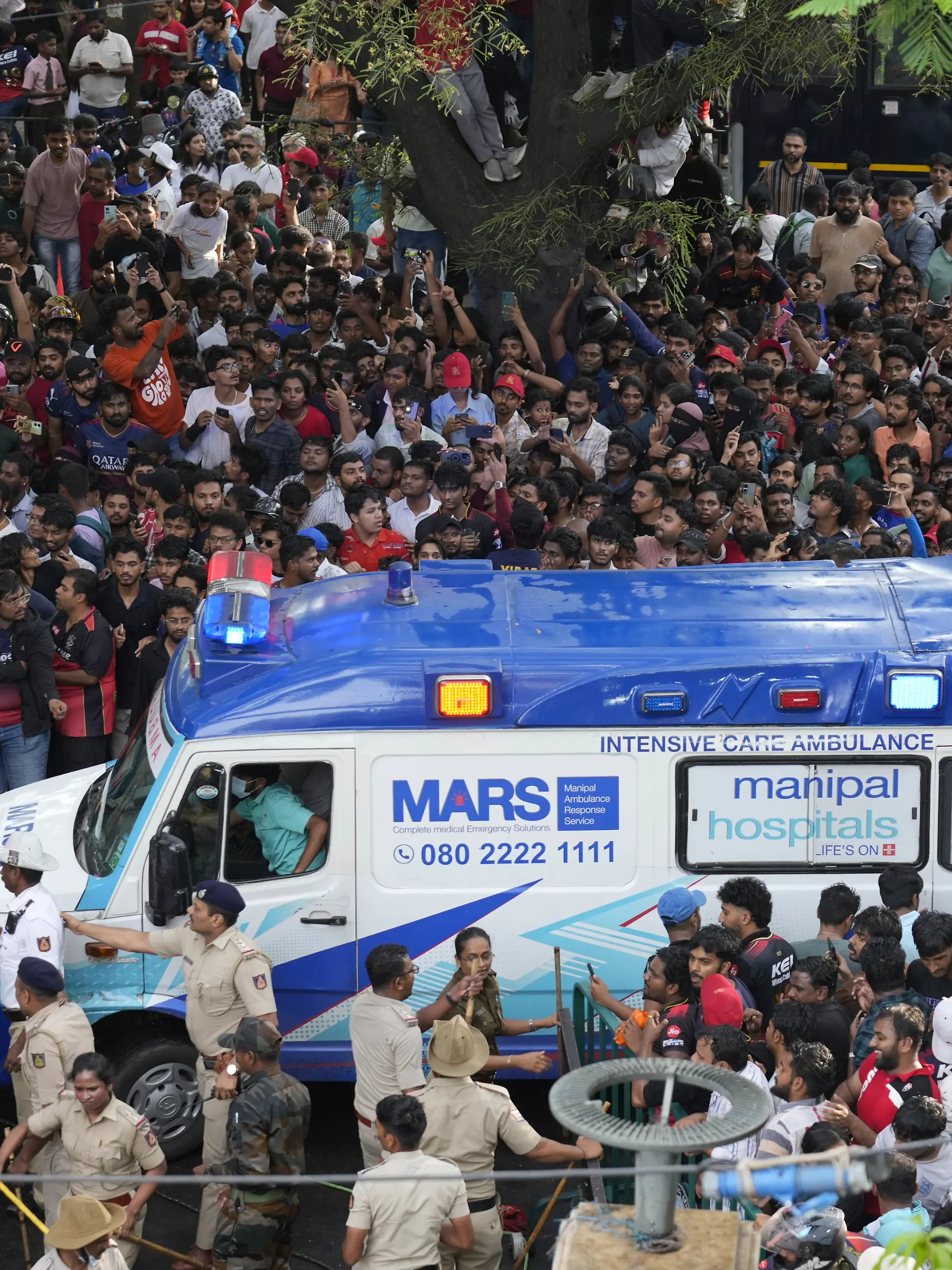 Ein Krankenwagen bahnt sich den Weg durch die Fan-Massen am Stadion. 