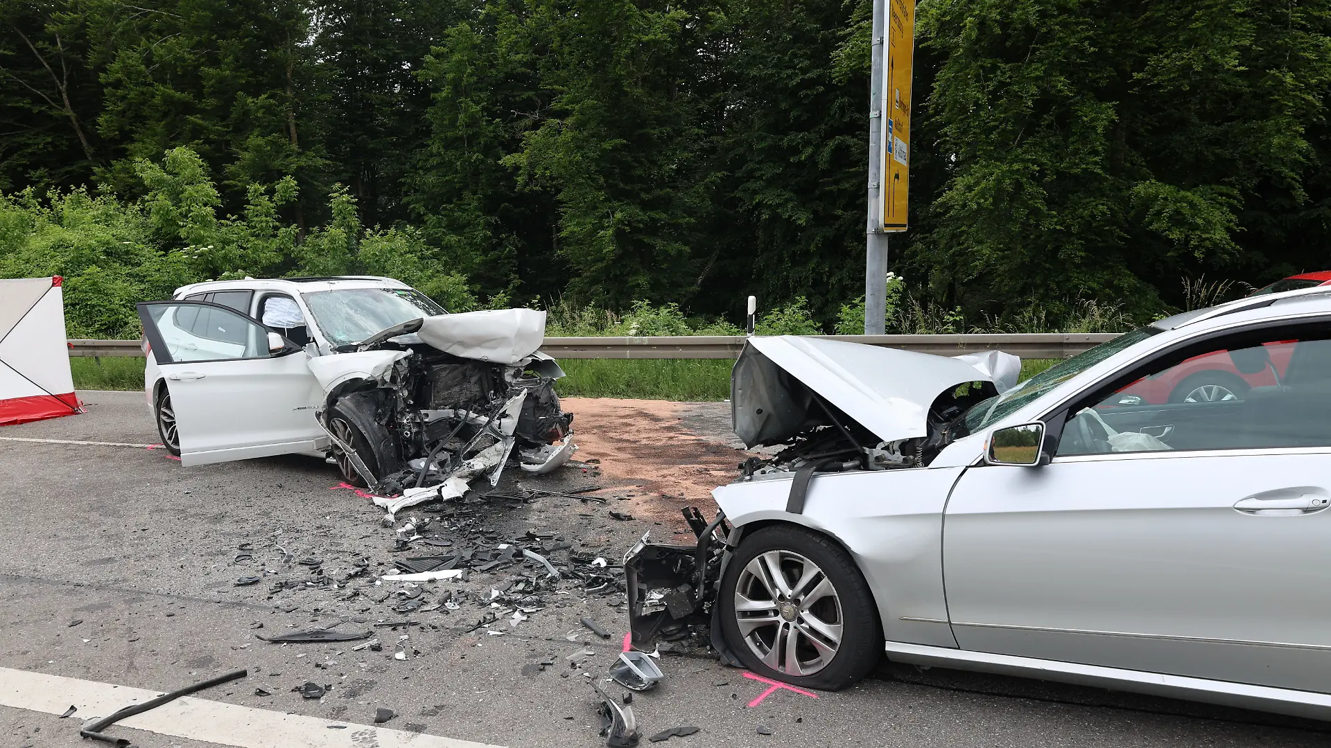 Zwei Unfallfahrzeuge stehen auf der Bundesstraße B31. Bei dem schweren Verkehrsunfall am Bodensee sind drei Menschen ums Leben gekommen. Drei weitere wurden nach Angaben der Polizei schwer verletzt. Ersten Erkenntnissen zufolge war ein Autofahrer am Nachmittag in einer Rechtskurve auf die Gegenfahrbahn geraten. In der Folge stieß er frontal gegen einen entgegenkommenden Wagen. In beiden Fahrzeugen saßen jeweils drei Insassen.