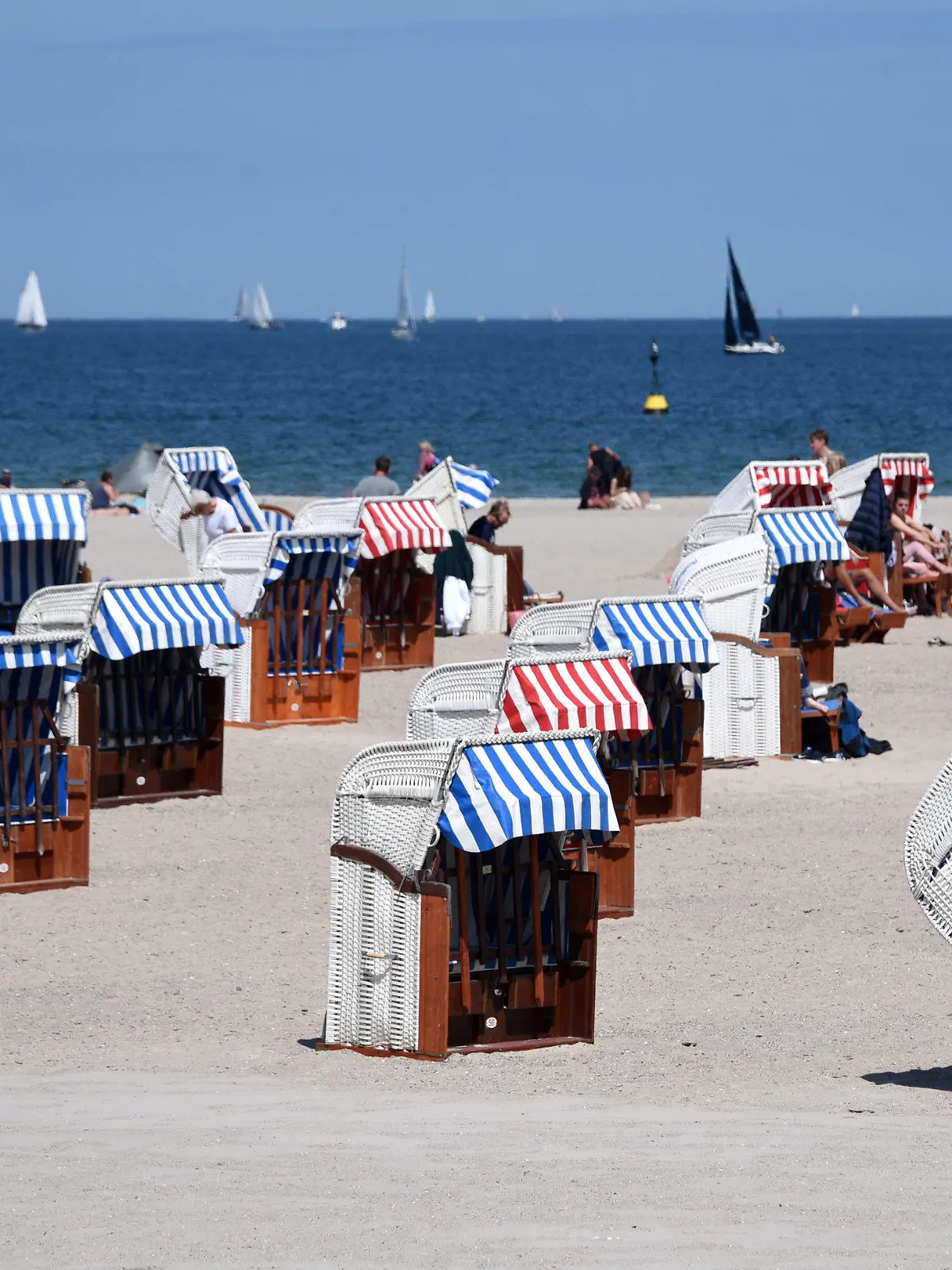 21.05.2020, Schleswig-Holstein, Lübeck-Travemünde: Nur wenige Strandkörbe sind am Strand an der Ostsee besetzt. Aufgrund der Abstandsregeln während der Corona-Pandemie stehen die Strandkörbe auch einige meterweit von einander entfernt. Foto: Daniel Bockwoldt/dpa +++ dpa-Bildfunk +++