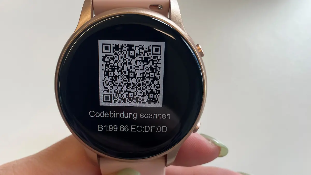 Redakteurin hält rosane Smartwatch in der Hand.