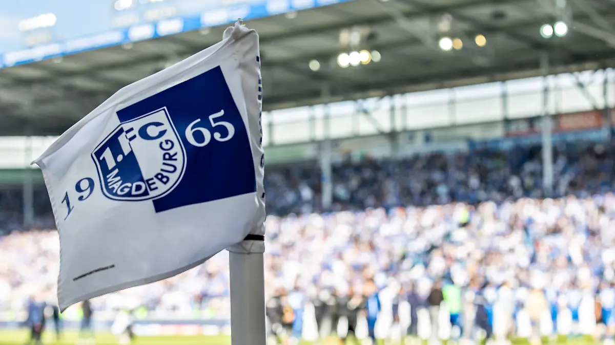 Eine Eckfahne mit Wappen des 1. FC Magdeburg weht im Wind des Stadions.