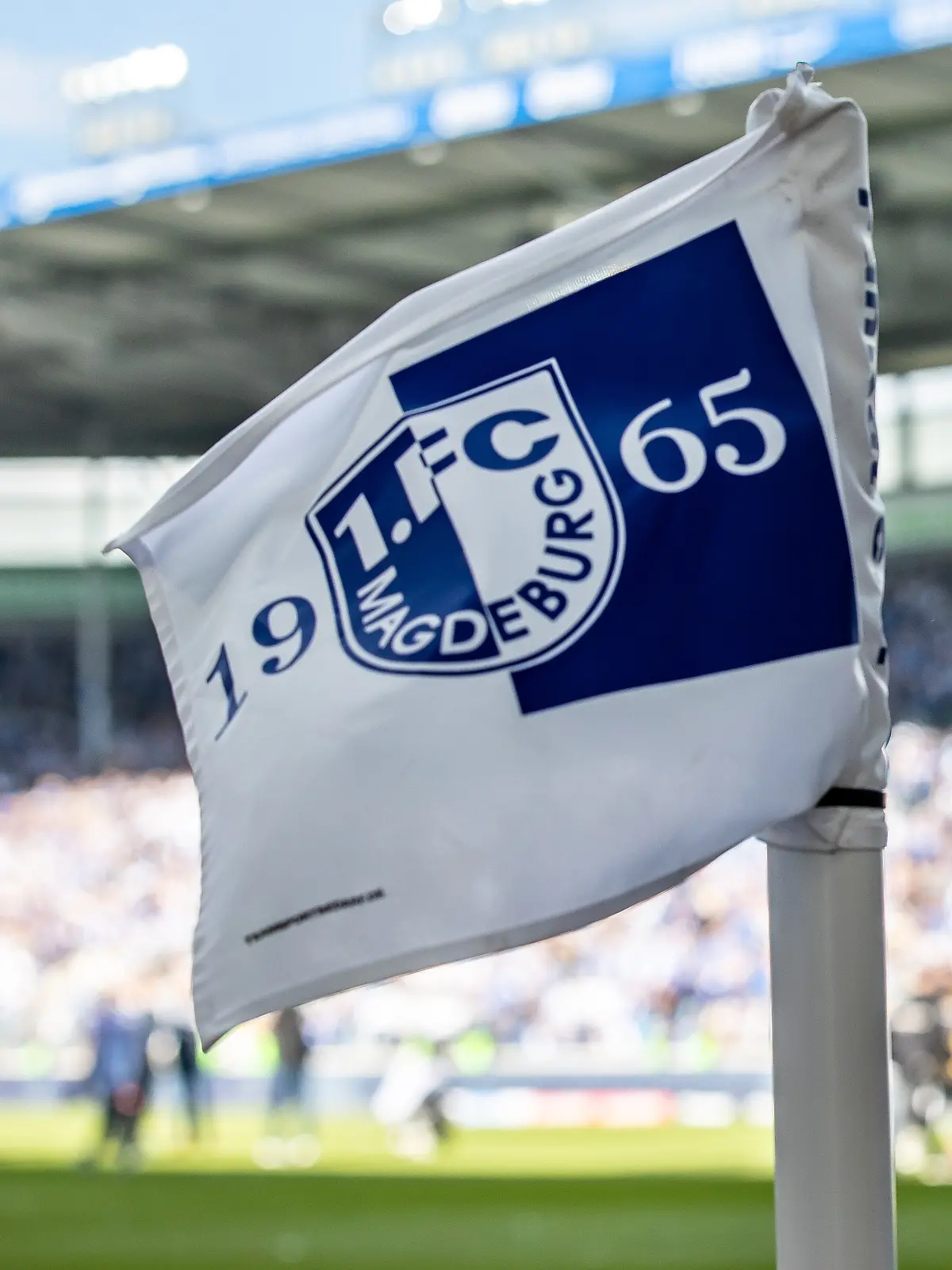 Eine Eckfahne mit Wappen des 1. FC Magdeburg weht im Wind des Stadions.