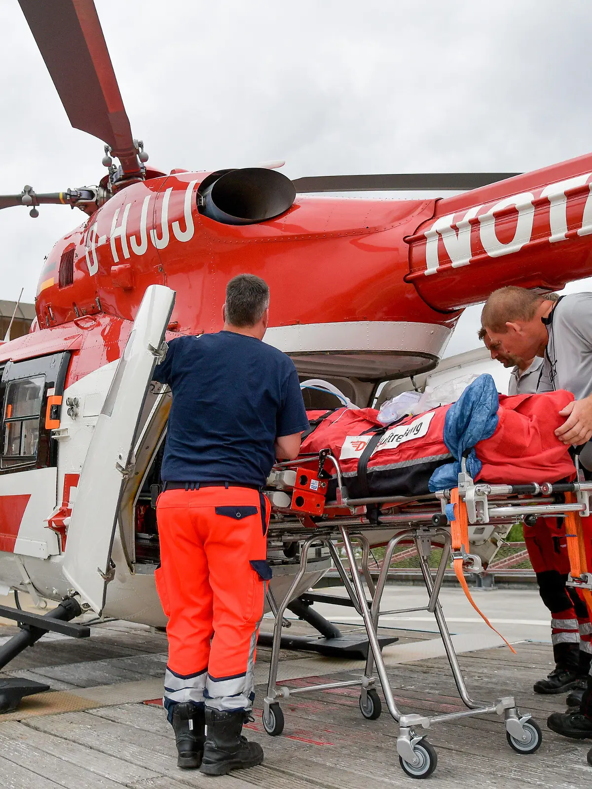 Sebastian Hilliger (r), Hubschrauberpilot der Deutschen Luftrettung (DRF, verdeckt), Notfallsanitäter Frank Schmelzkopf (r) und Notarzt Michael Schoenfeldt (l) verladen am 08.08.2016 in Rendsburg (Schleswig-Holstein) gemeinsam mit externen Notfallsanitätern einen Intensivpatienten in den Rettungshubschrauber Christoph 42, einer Maschine vom Typ BK 117 B2. 31 Stationen betreibt die DRF Luftrettung in Deutschland und Österreich, zwei davon in Schleswig-Holstein: in Rendsburg und in Niebüll. Foto: Axel Heimken/dpa (zu dpa Serie Chauffeure im Norden "Traumjob Pilot - Einsatz im Rettungshubschrauber" vom 17.08.2016) +++(c) dpa - Bildfunk+++