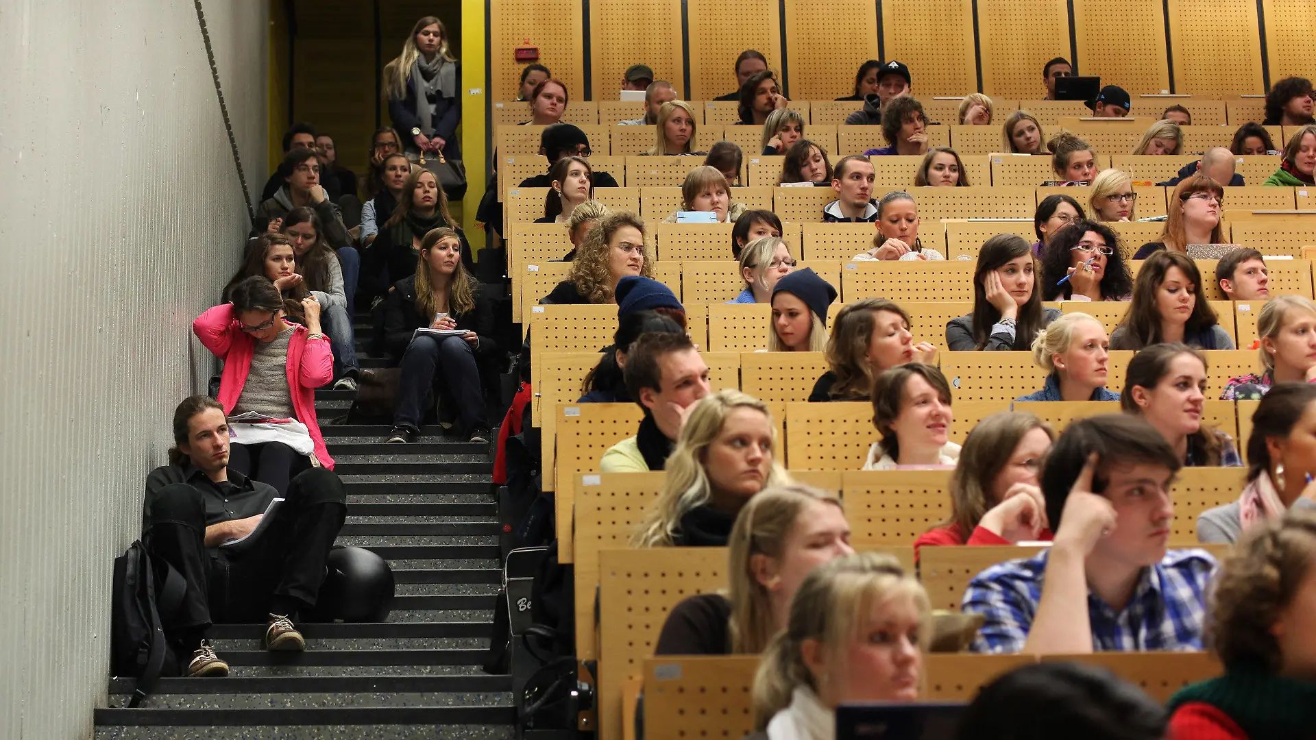 ARCHIV - Studenten sitzen am 17.10.2011 in einem Hörsaal der Ruhr-Universität in Bochum teilweise auf den Treppen und hören eine Vorlesung der Amerikanistik. Bund und Länder fürchten auch zum kommenden Herbst erneut ein Einschreibchaos an den Hochschulen. Das gegenwärtige Verfahren der Studienzulassung in den begehrten Numerus-clausus-Fächern (NC) sei weiterhin «unbefriedigend», heißt esübereinstimmend in Analysen von Bundesbildungsministerium undKultusministerkonferenz (KMK). Foto: Fabian Stratenschulte dpa/lnw (zu dpa-Korr-Bericht "Start ins Studium 2012: Einschreibungs-Chaos wie vor 40 Jahren" am 08.07.2012) +++(c) dpa - Bildfunk+++