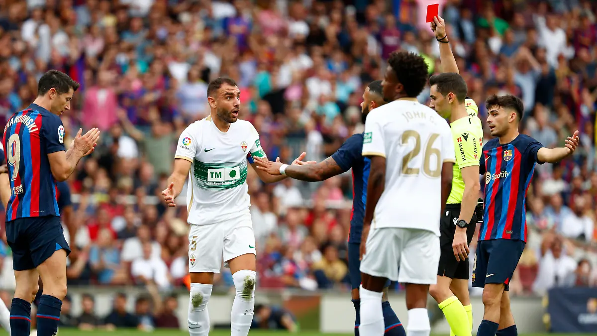 Referee Alejandro Muniz Ruiz shows a red card to Elche's Gonzalo Verdu, center, during a Spanish La Liga soccer match between FC Barcelona and Elche CF at Camp Nou stadium in Barcelona, Spain, Saturday, Sept. 17, 2022. (AP Photo/Joan Monfort)