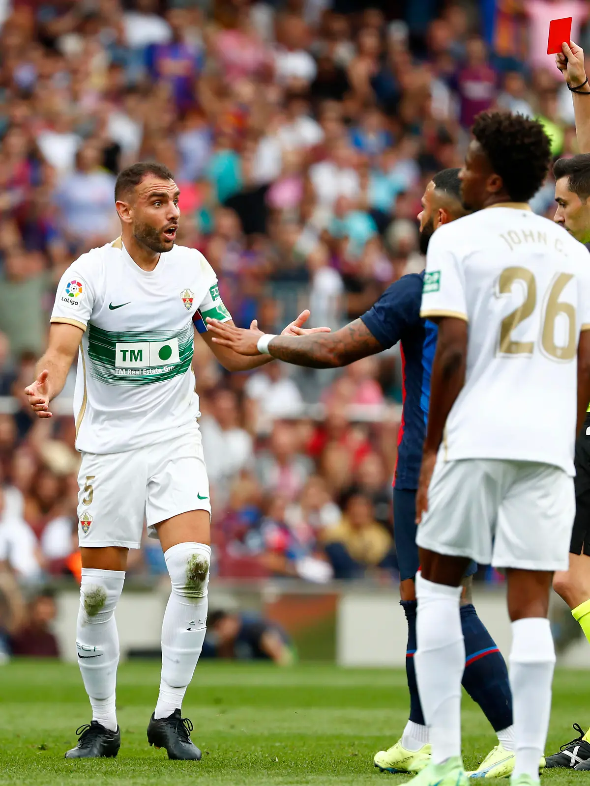 Referee Alejandro Muniz Ruiz shows a red card to Elche's Gonzalo Verdu, center, during a Spanish La Liga soccer match between FC Barcelona and Elche CF at Camp Nou stadium in Barcelona, Spain, Saturday, Sept. 17, 2022. (AP Photo/Joan Monfort)