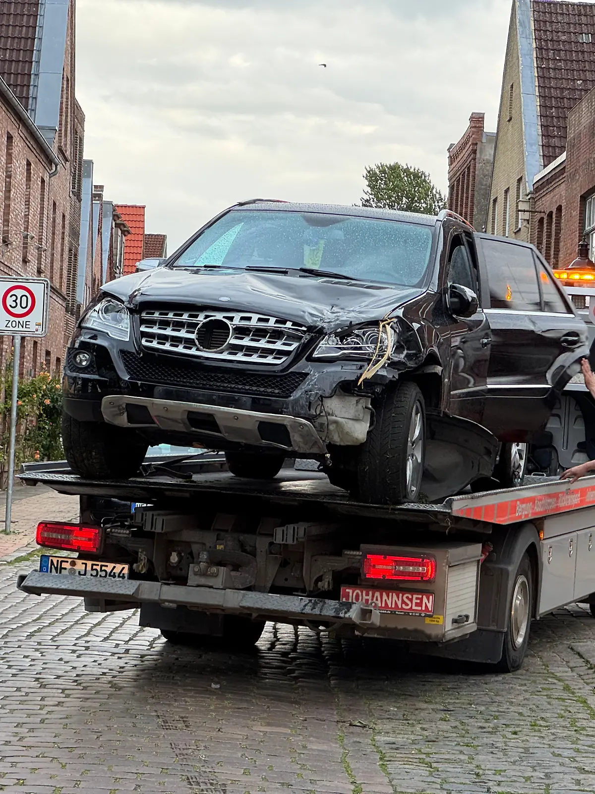 06.06.2025, Schleswig-Holstein, Friedrichstadt: Das Unfallfahrzeug wird auf einem Abschleppwagen abtransportiert. Ein Autofahrer hat in Nordfriesland auf einem Marktplatz die Kontrolle über seinen Wagen verloren und fünf Passanten verletzt. Foto: Georg Wendt/dpa +++ dpa-Bildfunk +++