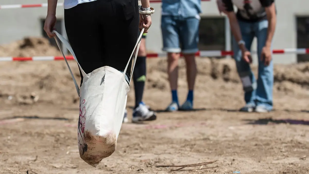 ARCHIV - 25.07.2014, Berlin: Eine junge Frau nimmt am Jutebeutel-Sackhüpfen beim Hipster Cup Festival in Berlin teil. (zu dpa: «Mehrere Verletzte bei Firmenolympiade») Foto: Paul Zinken/dpa +++ dpa-Bildfunk +++