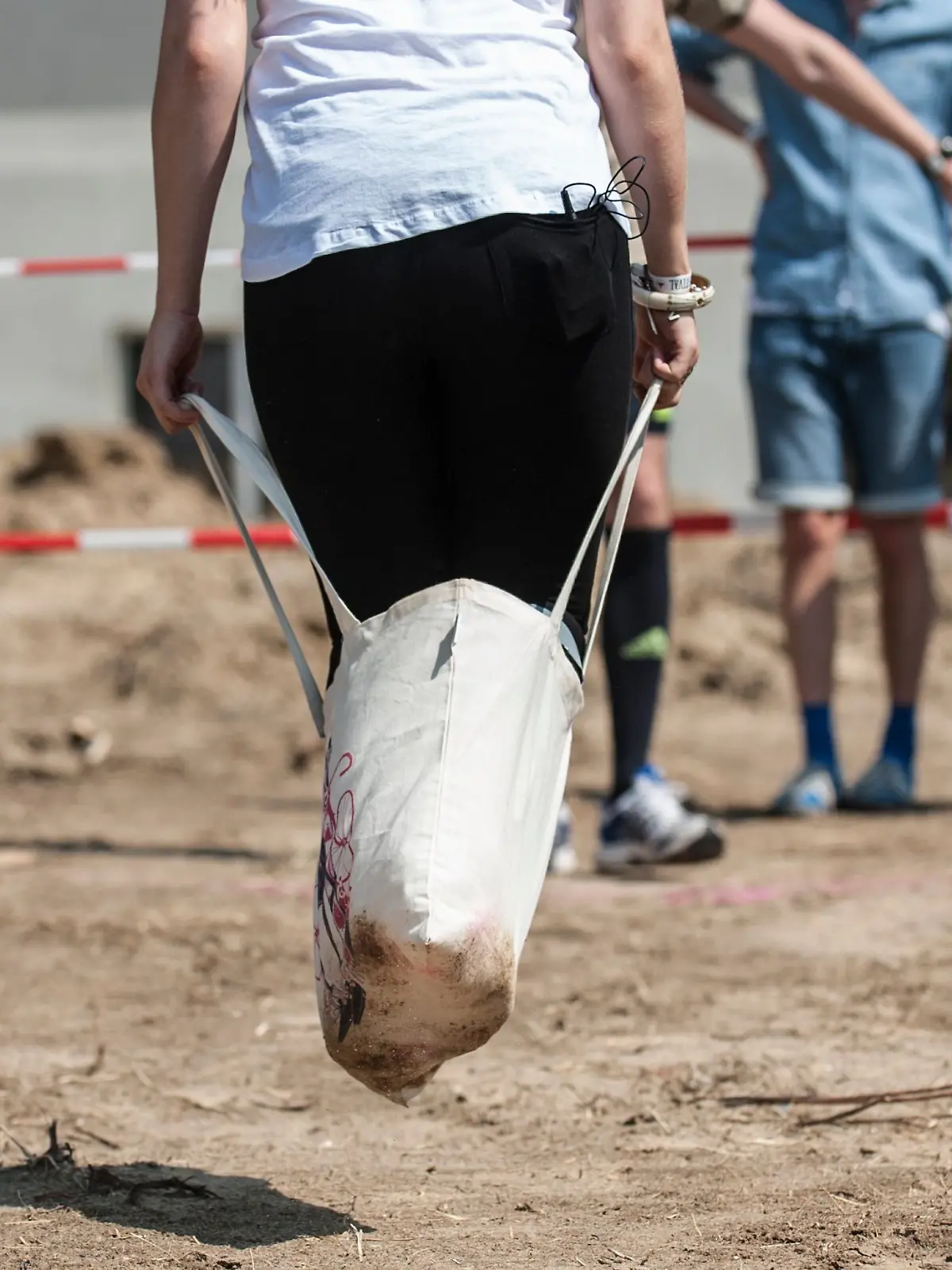 ARCHIV - 25.07.2014, Berlin: Eine junge Frau nimmt am Jutebeutel-Sackhüpfen beim Hipster Cup Festival in Berlin teil.  (zu dpa: «Mehrere Verletzte bei Firmenolympiade») Foto: Paul Zinken/dpa +++ dpa-Bildfunk +++