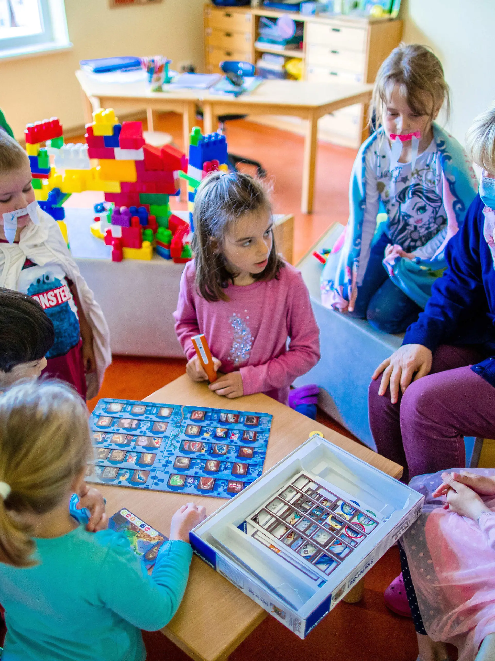20.05.2020, Mecklenburg-Vorpommern, Schwerin: Erzieherin Katrin Dorn spielt mit den Kinder der Vorschulgruppe in der Kindertagesstätte "Anne Frank". In den Kitas von Mecklenburg-Vorpommern zieht langsam wieder Normalität ein. Als erste durften die Mädchen und Jungen der Vorschulgruppen ab dem 18.05.2020 wieder regulär in den Kindergarten gehen. Ab dem 25.05.2020 stehen die Krippen und Kindergärten dann wieder allen offen. Foto: Jens Büttner/dpa-Zentralbild/dpa - ACHTUNG: Nur zur redaktionellen Verwendung im Zusammenhang mit der aktuellen Berichterstattung. +++ dpa-Bildfunk +++