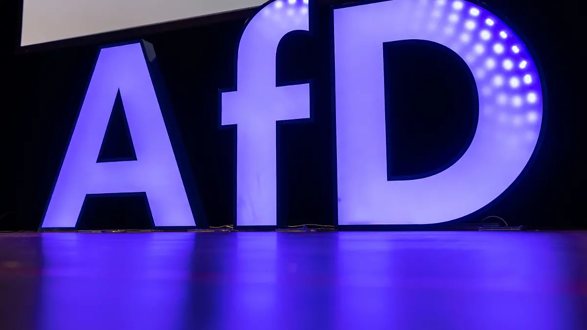 04.03.2023, Baden-Württemberg, Offenburg: Ein beleuchteter Schriftzug der AfD steht während dem Landesparteitag auf der Bühne. Die AfD Baden-Württemberg hält auf der Messe Offenburg ihren Landesparteitag ab. Bei einer Demonstration gegen den AfD-Parteitag ist es zu Auseinandersetzungen zwischen Teilnehmern und der Polizei gekommen. Foto: Philipp von Ditfurth/dpa +++ dpa-Bildfunk +++