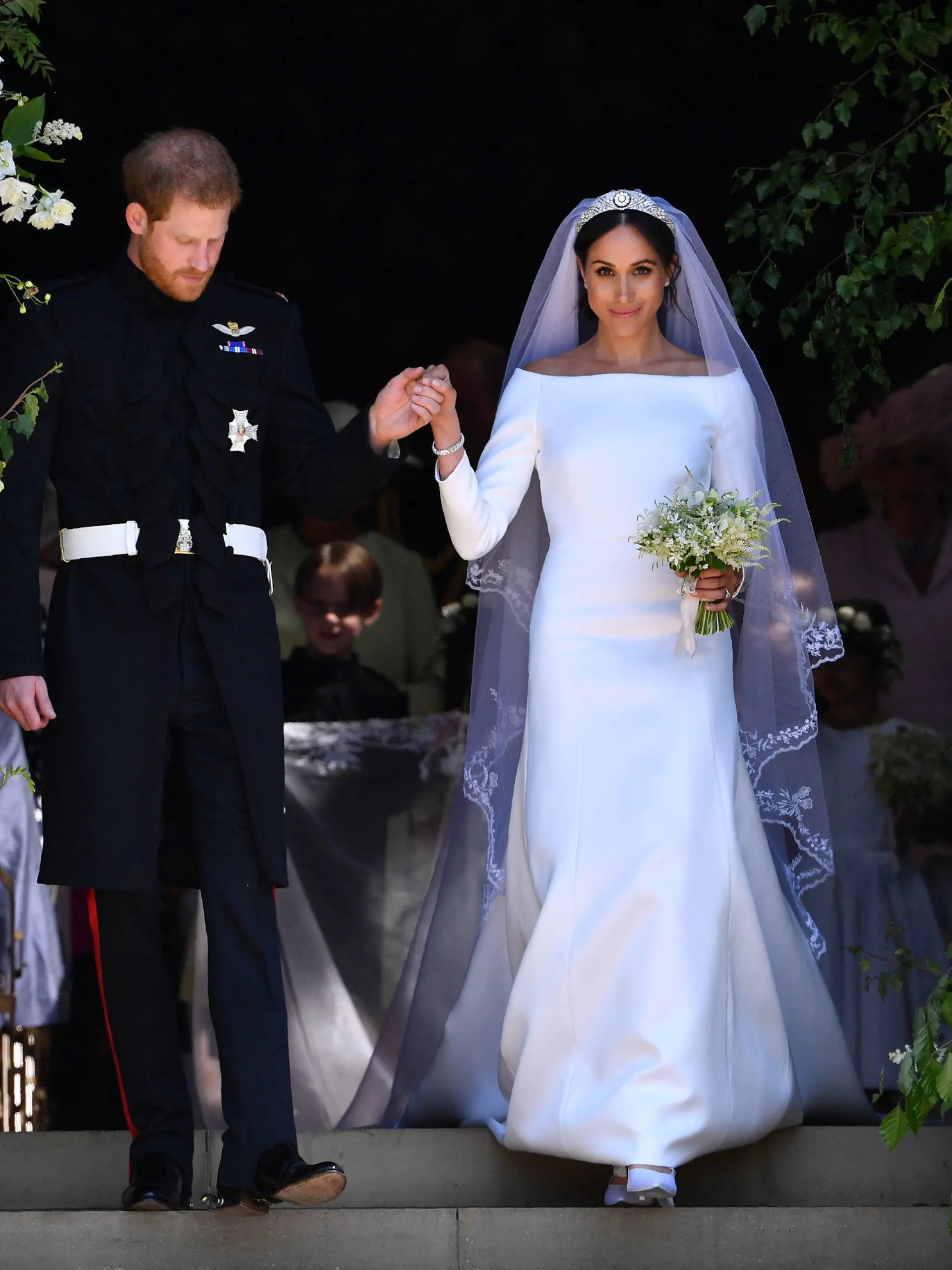 ARCHIV - 19.05.2018, Großbritannien, Windsor: Der britische Prinz Harry und seine Frau Meghan verlassen die St.-Georgs-Kapelle nach der Trauung. Zwei Jahre nach der Hochzeit leben Prinz Harry und Meghan in den USA - er hat alles hinter sich gelassen, sie ist zurück in ihrer Heimat. Viele blicken mit gemischten Gefühlen auf die Heirat zurück. (zu dpa "Ein zerbrochenes Diadem und was von Harrys und Meghans Hochzeit blieb") Foto: Ben Stansall/POOL AFP/AP/dpa +++ dpa-Bildfunk +++