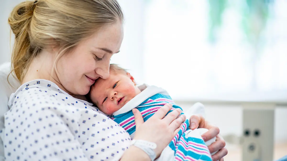 Mutter hält Baby im Wochenbett