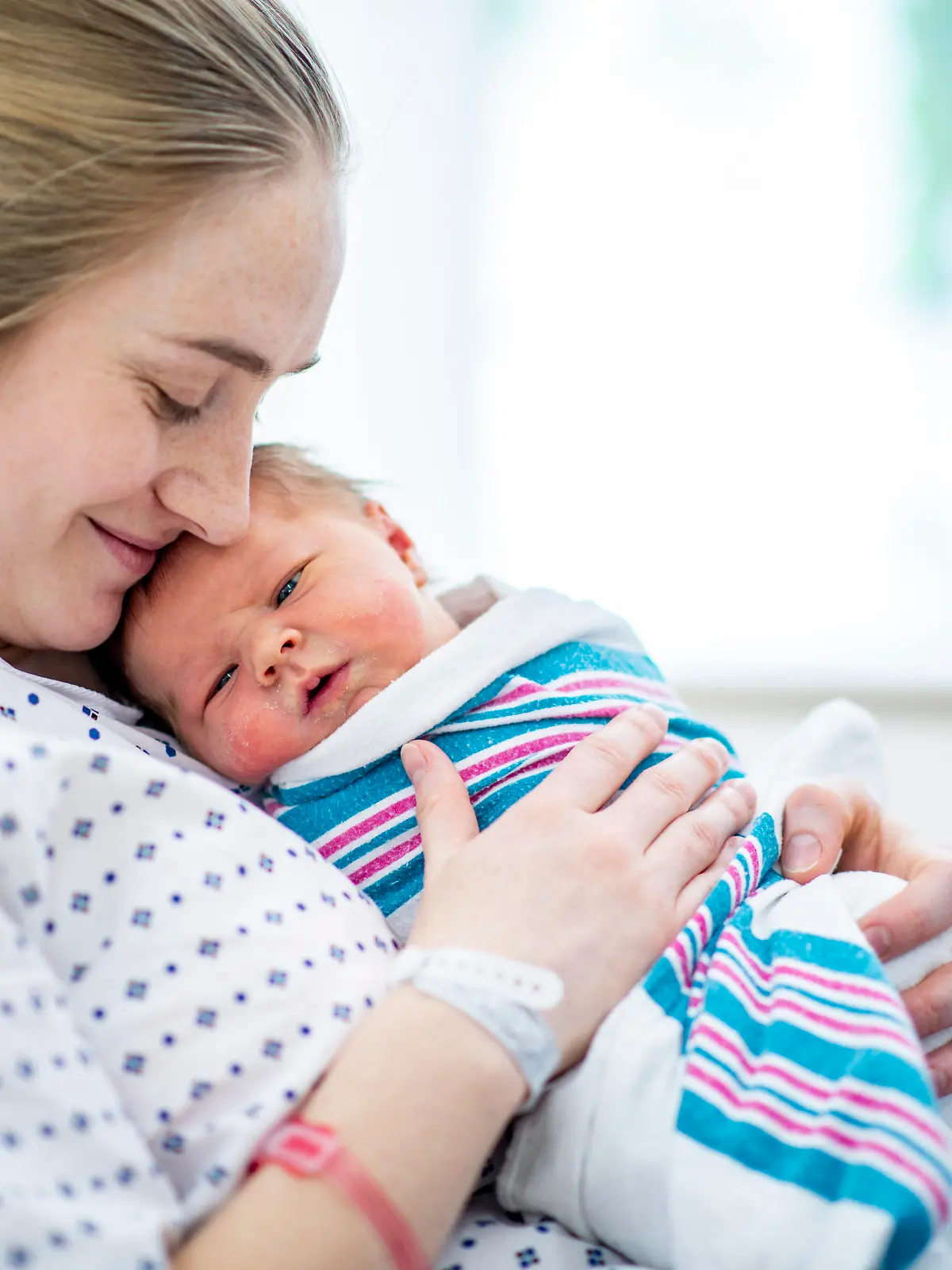 Mutter hält Baby im Wochenbett