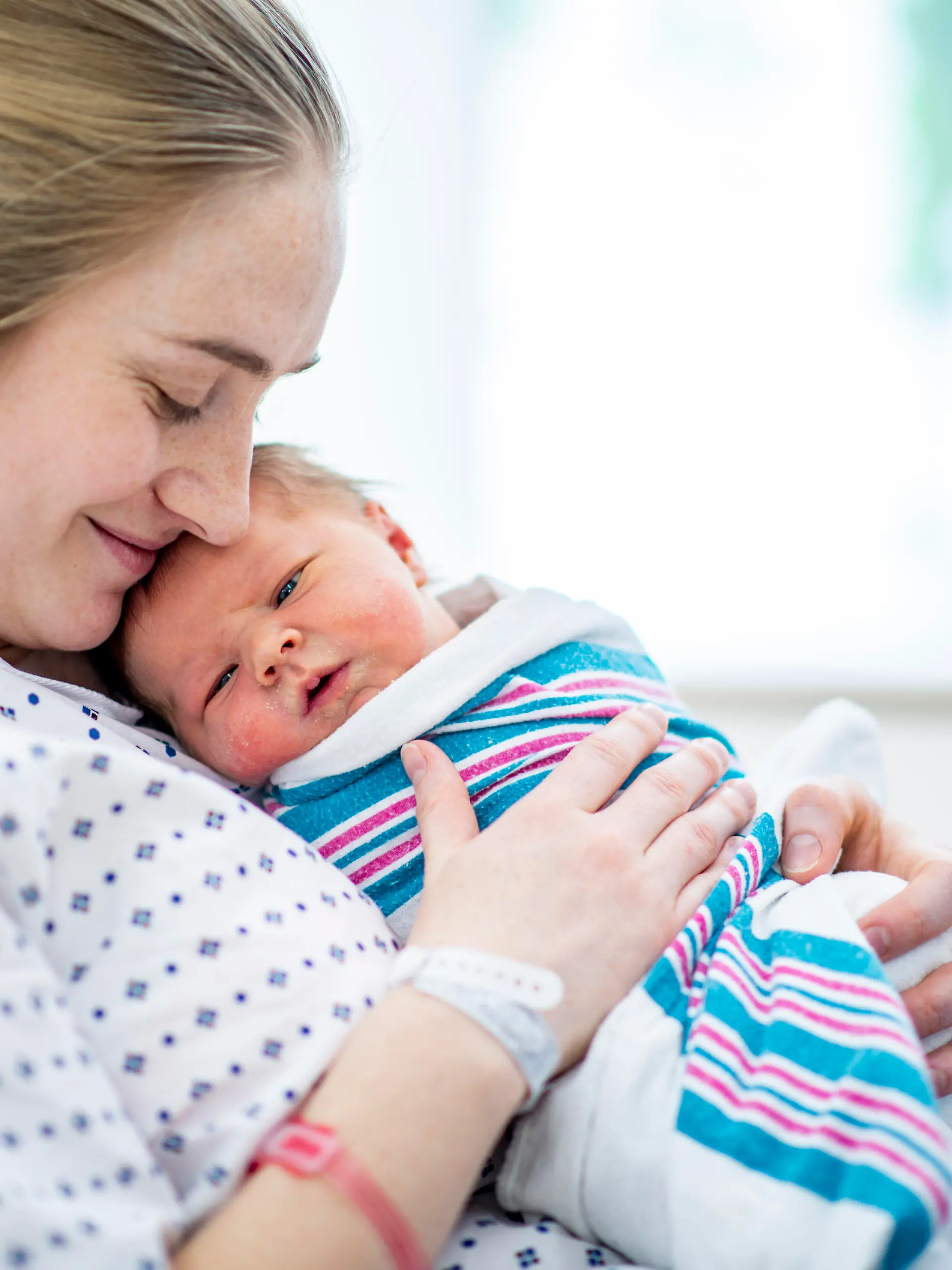 Mutter hält Baby im Wochenbett
