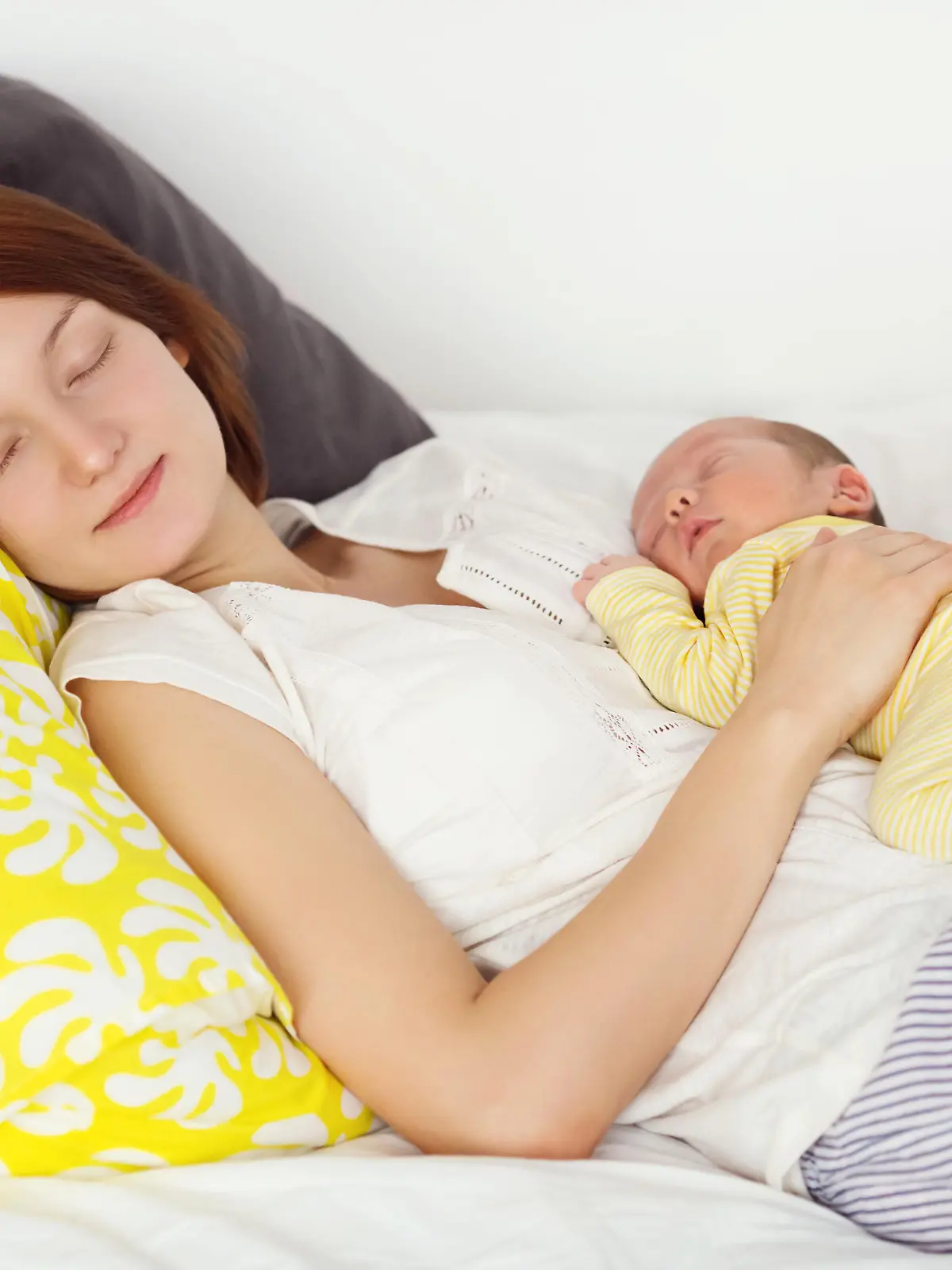 Mutter schläft mit Baby im Arm