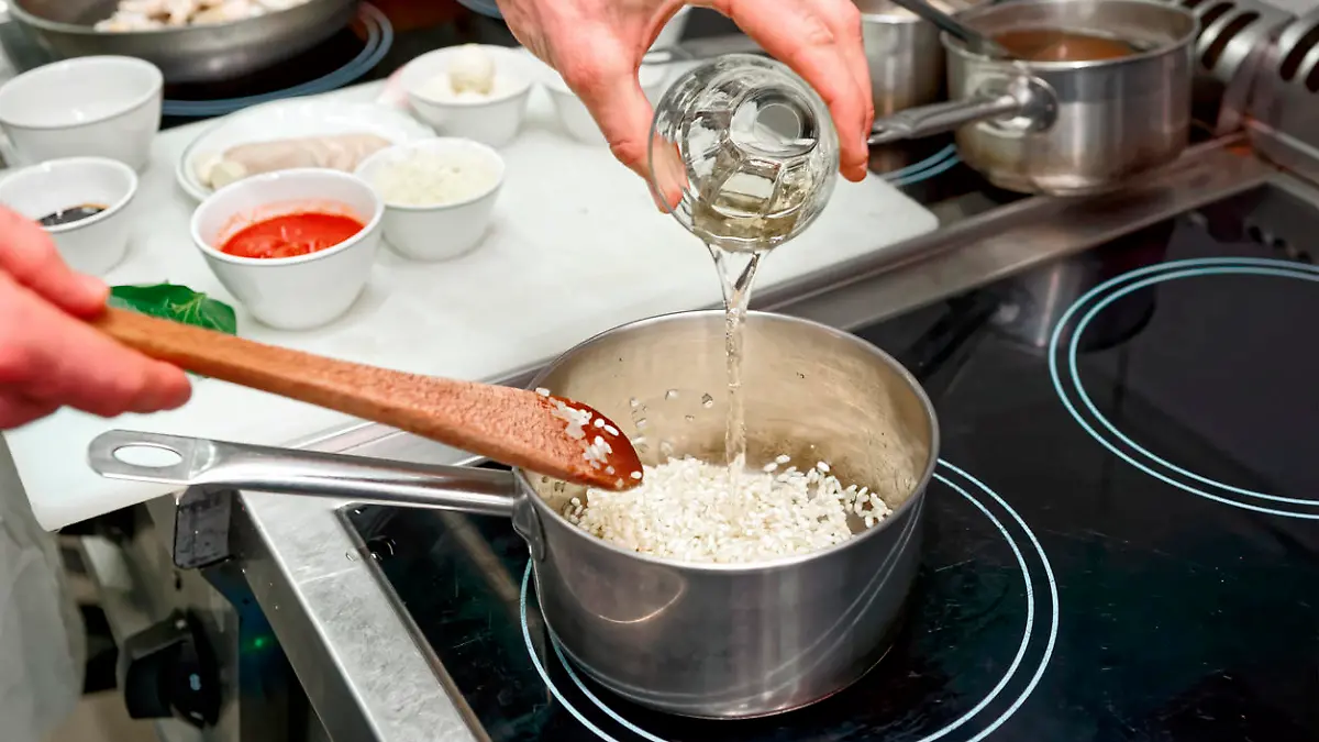 Koch fügt Weißwein zum Risotto hinzu