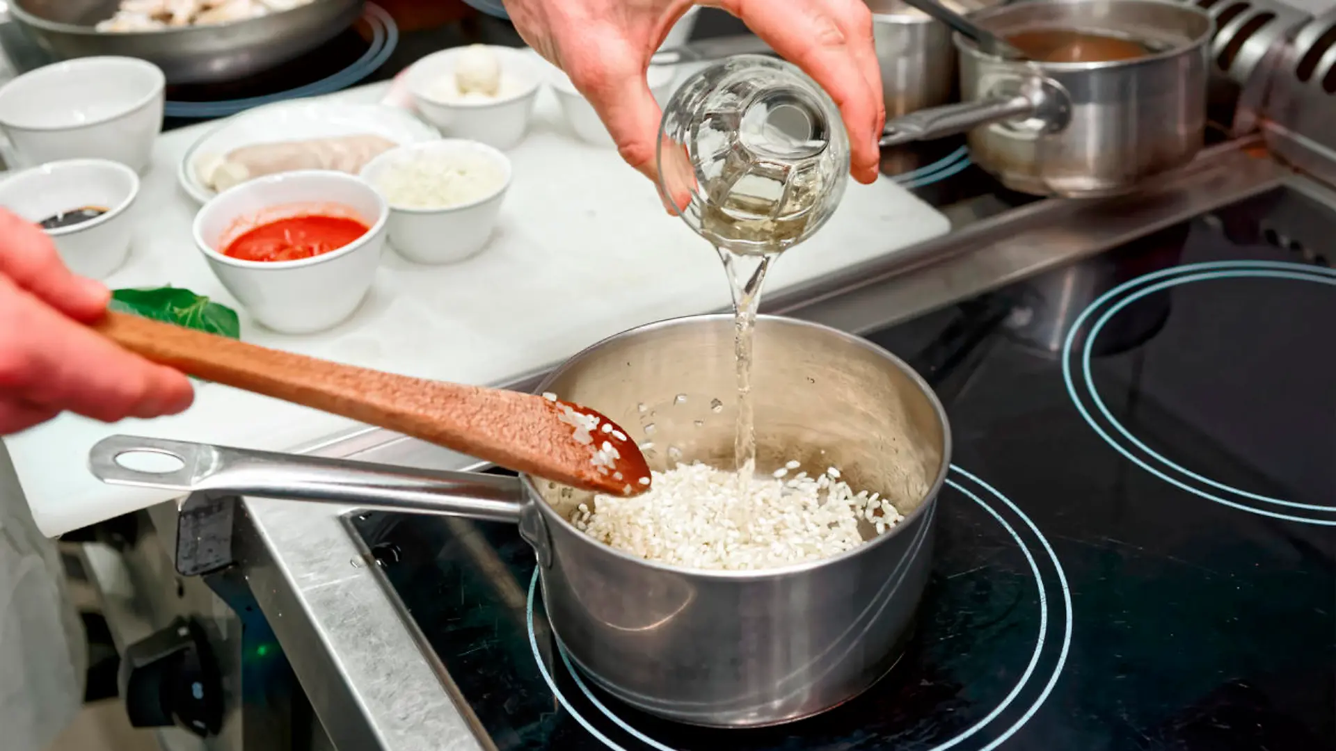 Koch fügt Weißwein zum Risotto hinzu