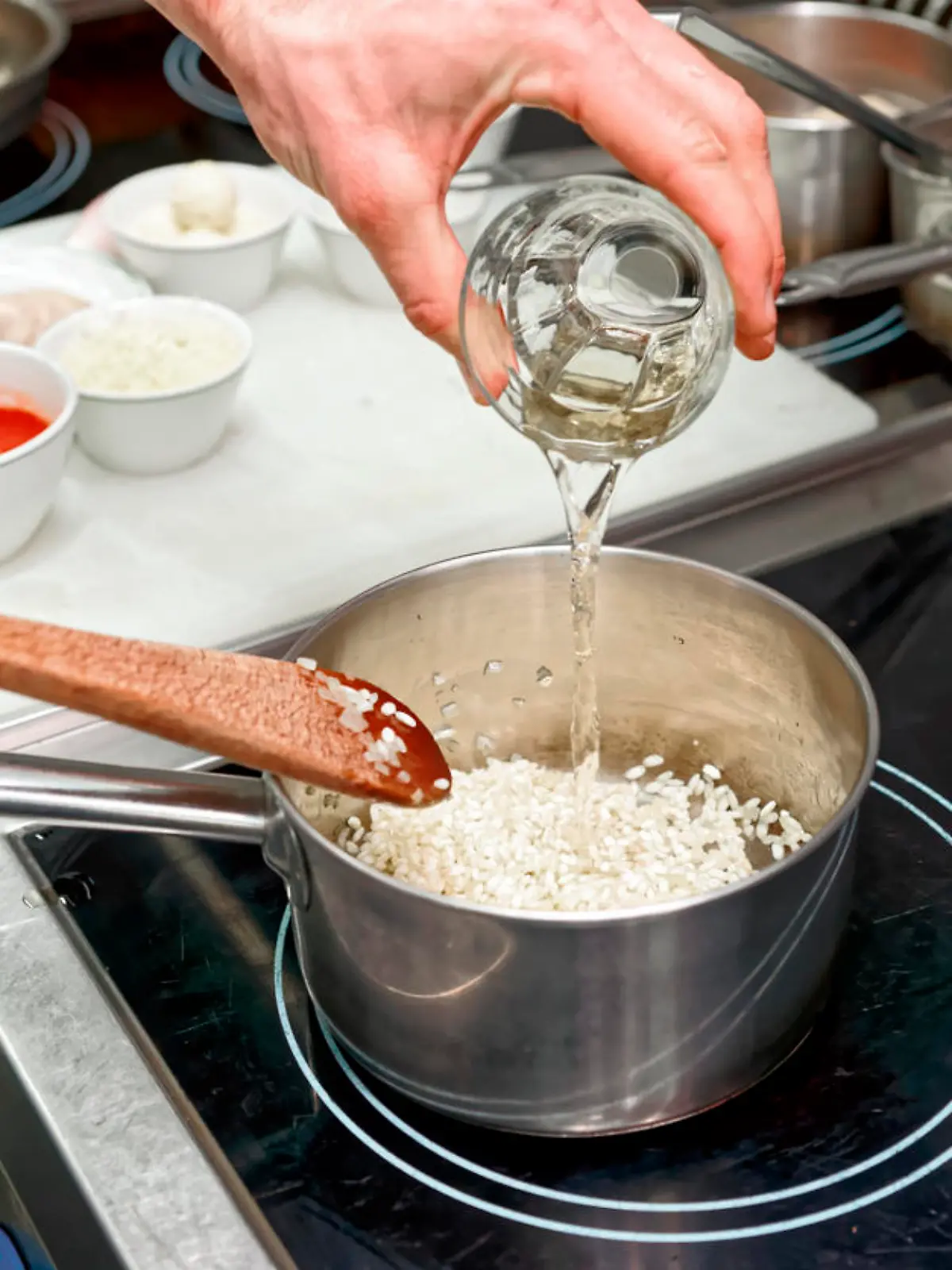 Koch fügt Weißwein zum Risotto hinzu