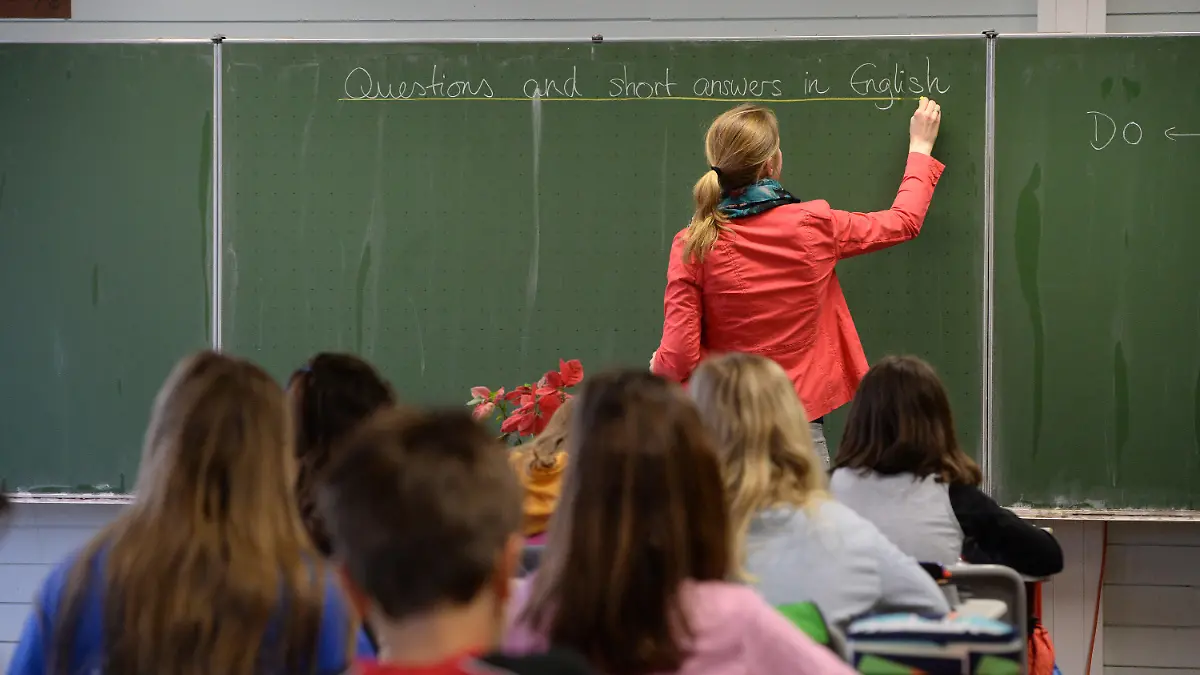 ARCHIV - Eine Studienrätin schreibt am 20.05.2015 in einem Klassenzimmer im Theodor-Heuss-Gymnasium in Esslingen (Baden-Württemberg) an die Tafel. Hunderte Lehrer aus Sachsen-Anhalt haben in den vergangenen Jahren Anträge auf Versetzung in ein anderes Bundesland gestellt - noch mehr wollten allerdings nach Sachsen-Anhalt kommen. Foto: Marijan Murat/dpa (zu lah «Stühlerücken: Hunderte Lehrer wollen über Landesgrenze wechseln» vom 02.11.2015) +++(c) dpa - Bildfunk+++