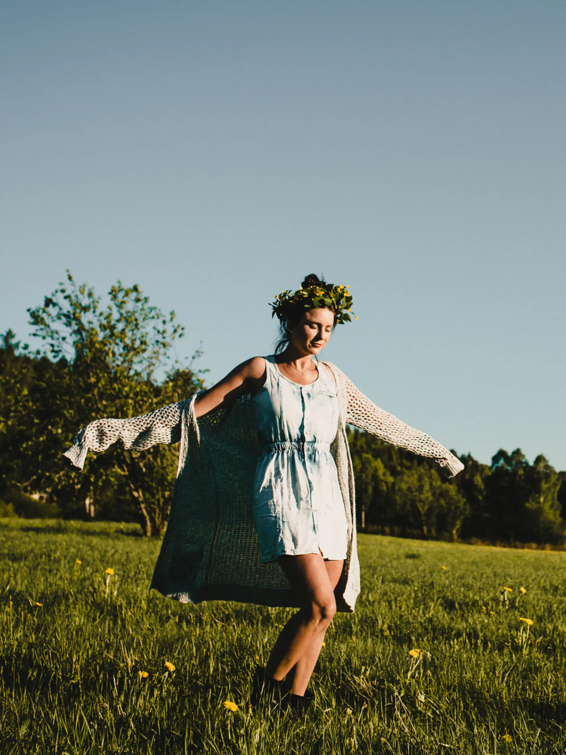Eine schwedische Frau tanzt im Feld am Mittsommerfest.