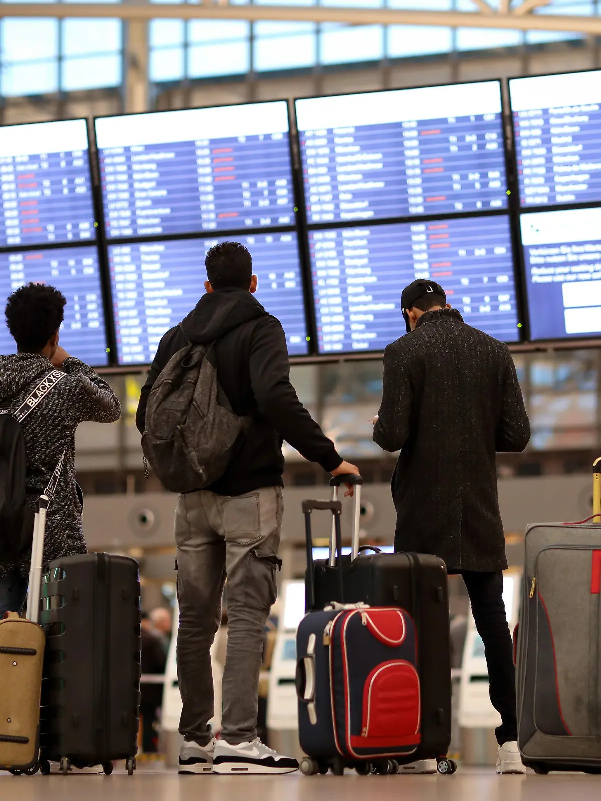 15.01.2019, Hamburg: Fluggäste stehen vor einer Anzeigetafel im Terminal 1 des Flughafens Hamburg. An mehreren deutschen Flughäfen ist seit dem frühen Morgen das Sicherheitspersonal im Ausstand. Foto: Christian Charisius/dpa +++ dpa-Bildfunk +++