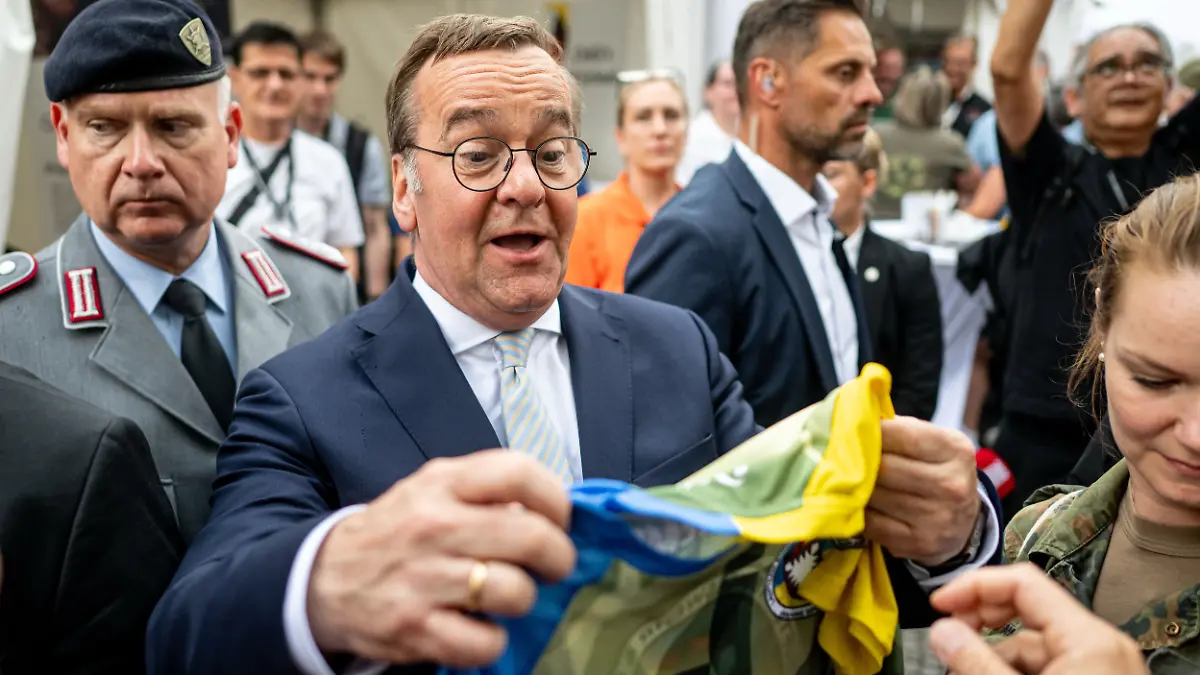 Boris Pistorius (SPD), Bundesminister der Verteidigung, bekommt am Nationalen Veteranentag auf dem Bürgerfest rund um das Reichstagsgebäude ein Trikot vom Laufteam Bundeswehr.