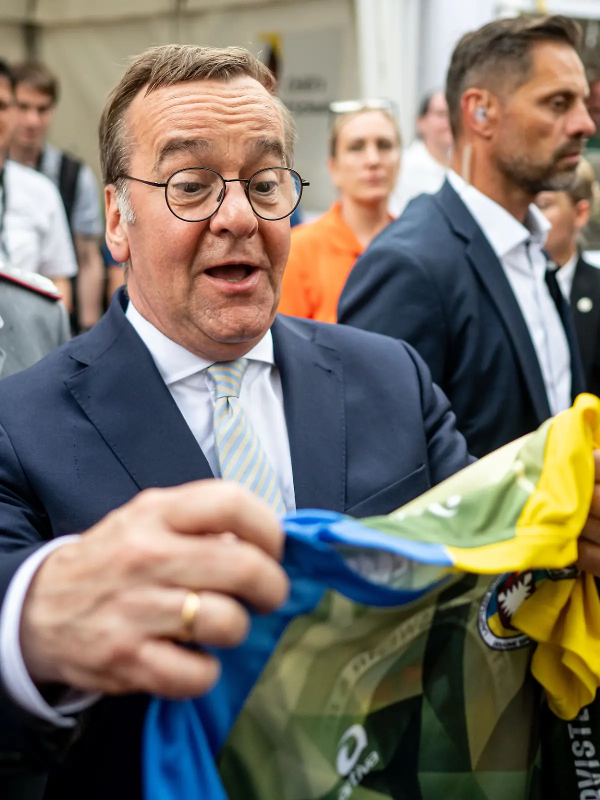 Boris Pistorius (SPD), Bundesminister der Verteidigung, bekommt am Nationalen Veteranentag auf dem Bürgerfest rund um das Reichstagsgebäude ein Trikot vom Laufteam Bundeswehr.