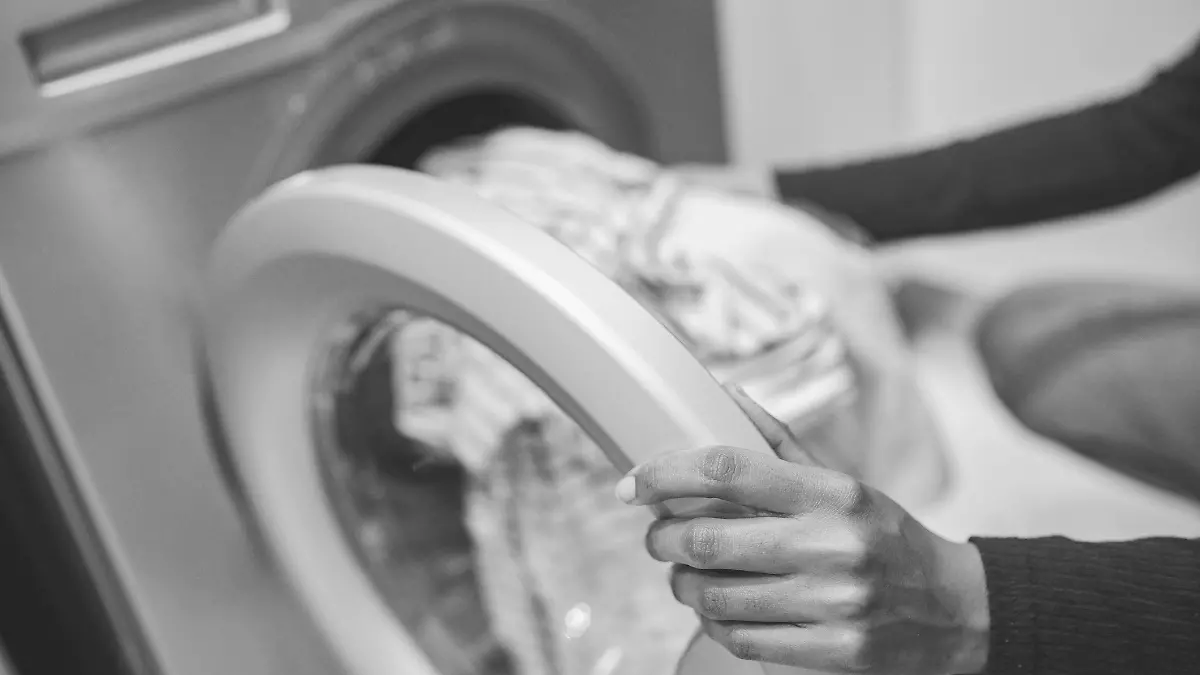 Frau packt Kleidung in Waschmaschine