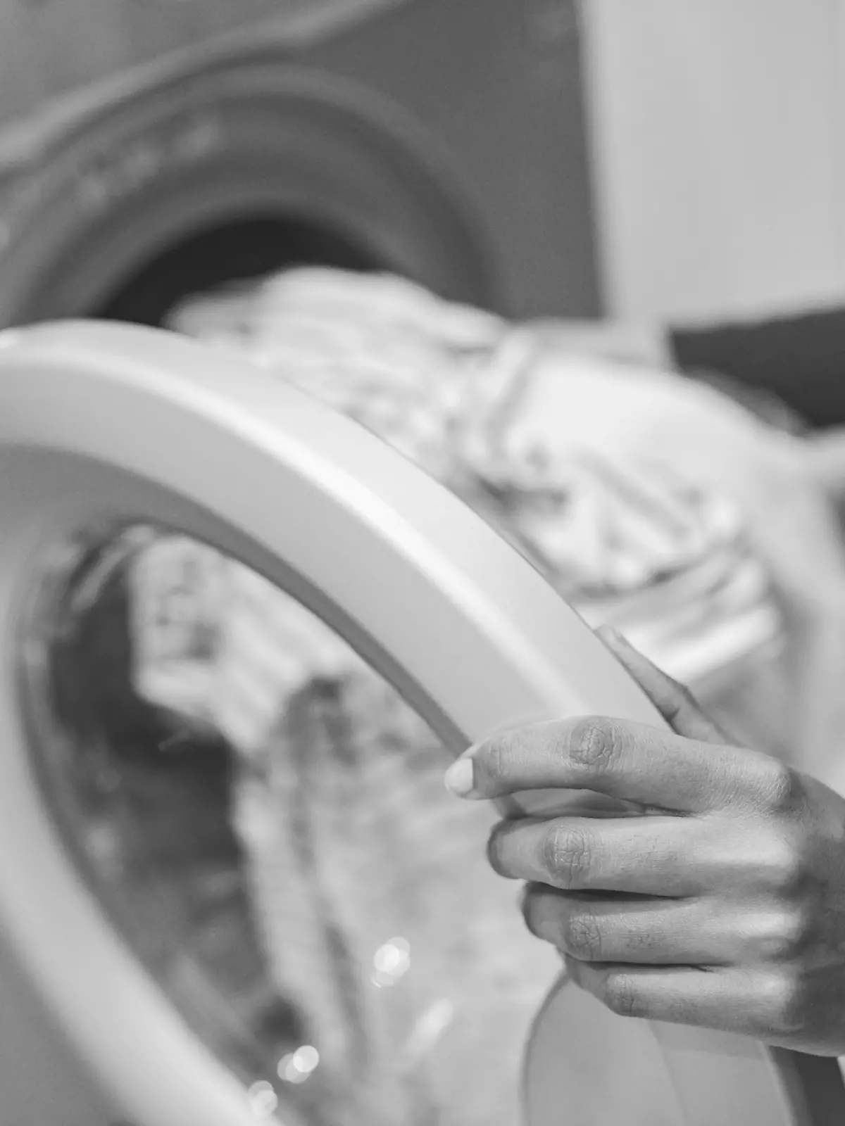 Frau packt Kleidung in Waschmaschine