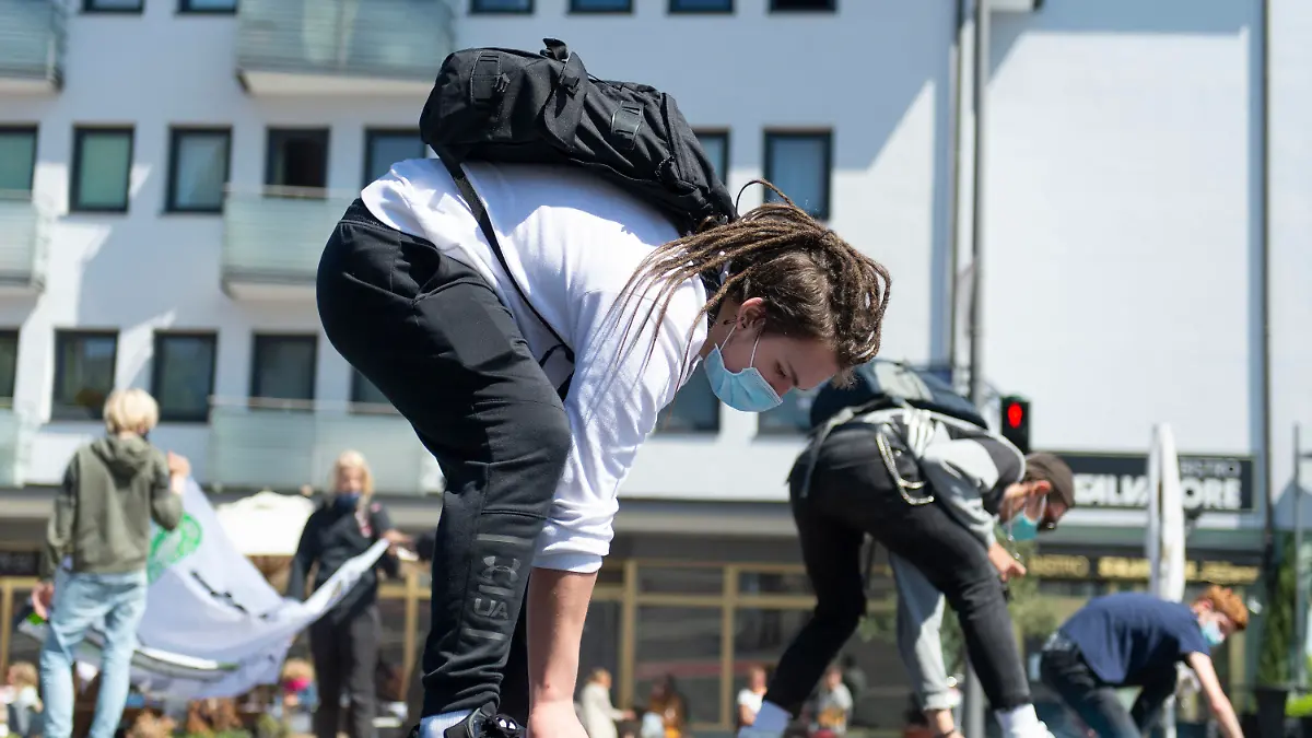 15.05.2020, Hessen, Frankfurt/Main: Einen Slogan sprühen Teilnehmer der Fridays for Future Demonstration auf den Asphalt. Es ist die erste reguläre Versammlung der Klimaaktivisten in Frankfurt nach drei Monaten. Foto: Sebastian Kramer/dpa +++ dpa-Bildfunk +++