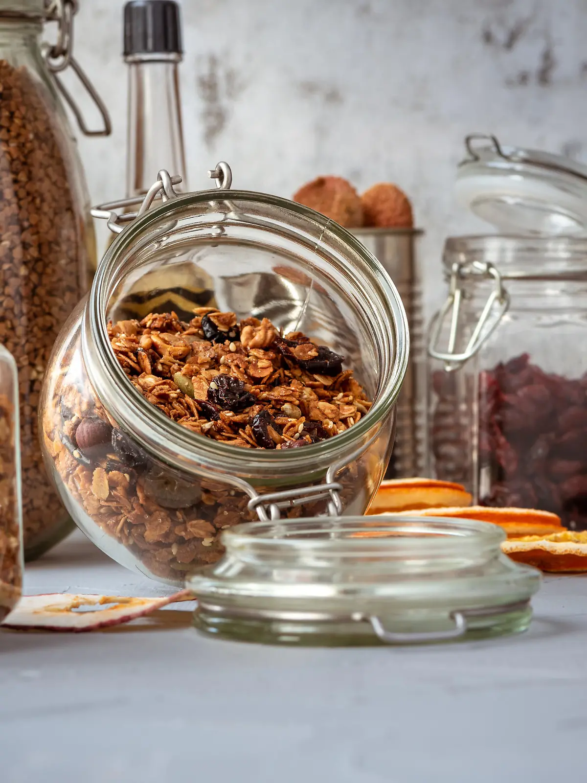 Glass jars with muesli in a on table in kitchen or pantry for topping, ingredients of dessert or breakfast.