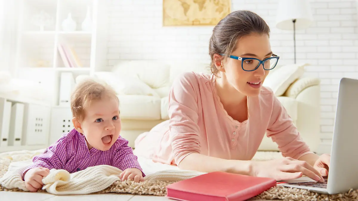 Eine Frau mit Baby arbeitet in der Elternzeit