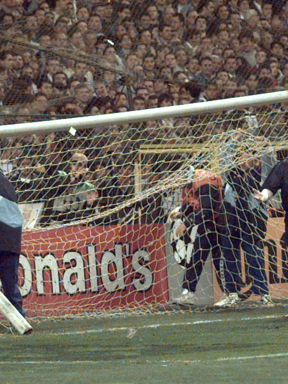 ARCHIV - Ein Linienrichter geht am 01.04.1998 im Stadion Santiago Bernabeu in Madrid von dem umgestürzten Tor weg. Vor dem Champions-League-Halbfinale zwischen Real Madrid und Borussia Dortmund hatten Fans den Zaun hinter dem Tor eingerissen. Der daran befestigte Kasten und das Tor stürzten um. Foto: dpa (zu dpa 0834 vom 05.11.2012)  +++(c) dpa - Bildfunk+++