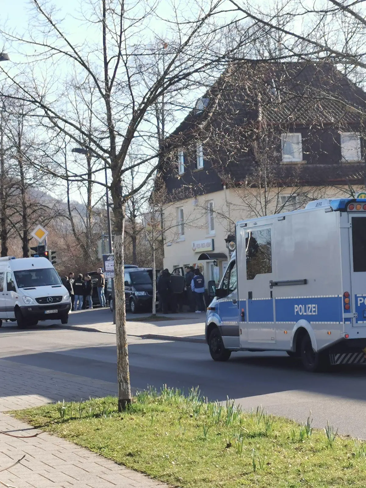 22.03.2023, Baden-Württemberg, Reutlingen: Polizeifahrzeuge stehen in einer Straße. Bei bundesweiten Durchsuchungen im «Reichsbürger»-Milieu ist in Reutlingen ein Beamter eines Spezialeinsatzkommandos durch einen Schuss leicht verletzt worden. Foto: Thomas de Marco/Schwäbisches Tagblatt /dpa +++ dpa-Bildfunk +++