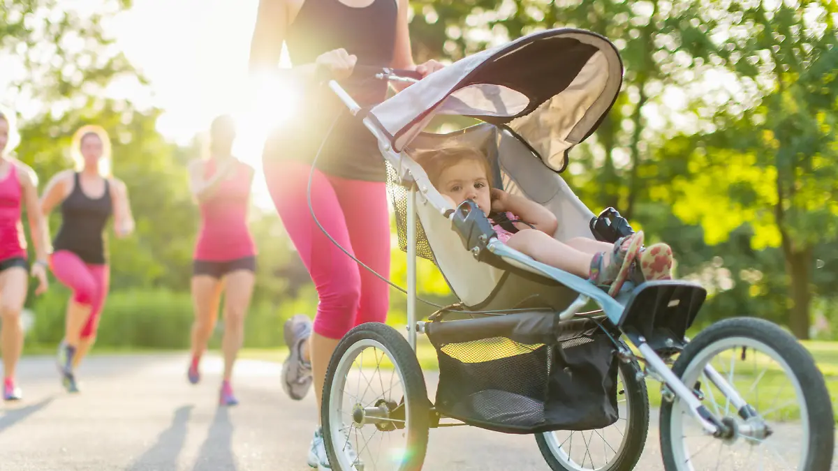 Mutter joggt mit Baby im Buggy