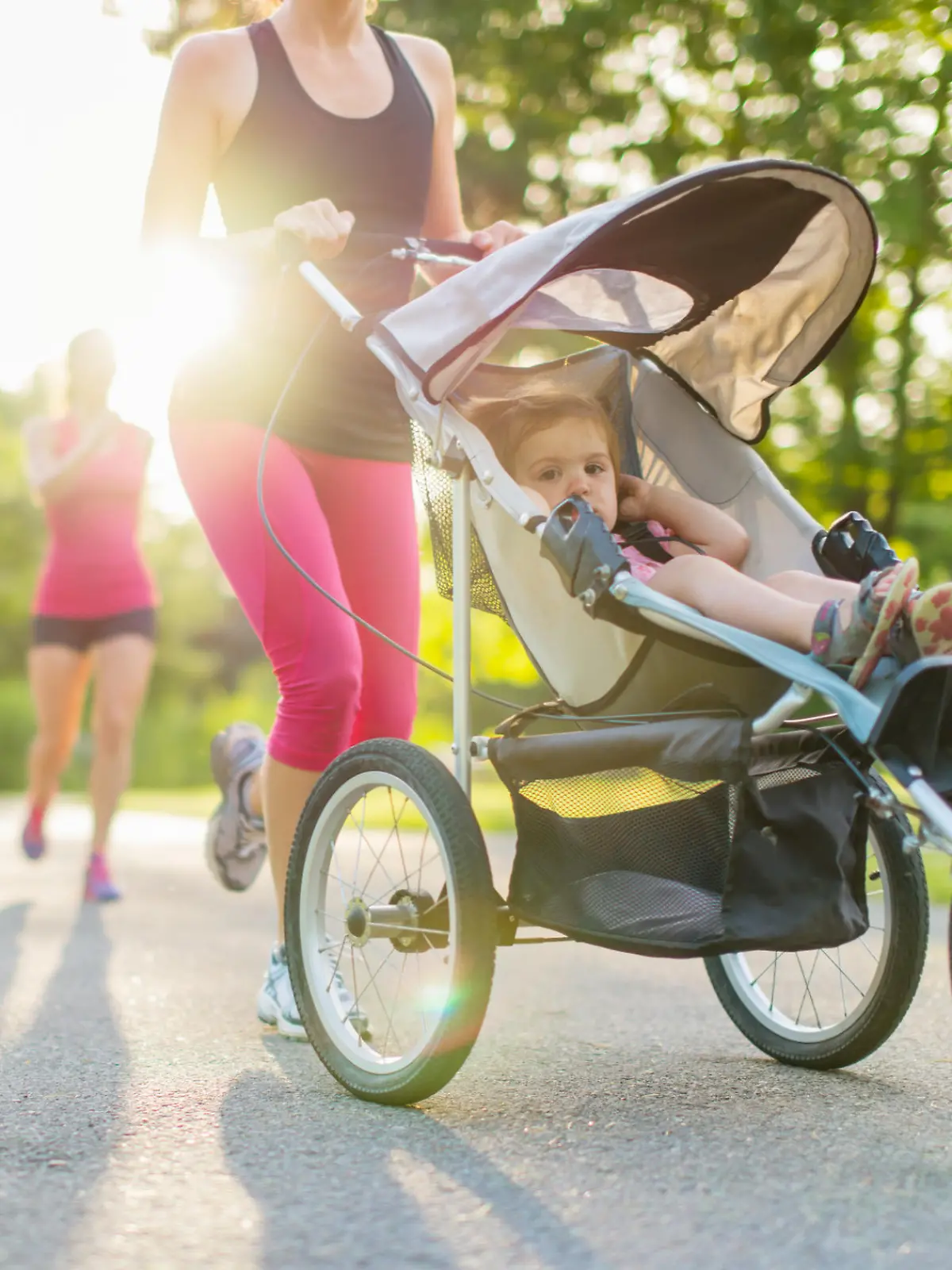 Mutter joggt mit Baby im Buggy