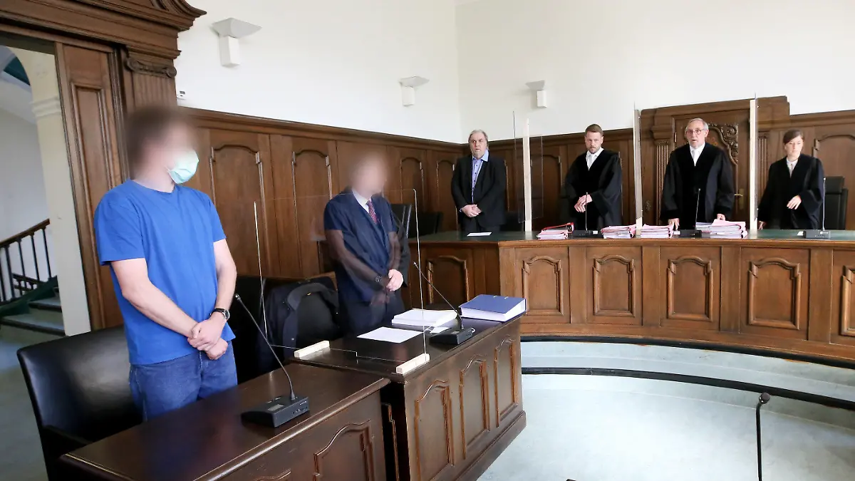 12.05.2020, Nordrhein-Westfalen, Moers: Der vorsitzende Richter Johannes Huismann (2.v.r) eröffnet den Prozess im Missbrauchsfall Bergisch Gladbach gegen den angeklagten Soldat (l). Neben dem Angeklagten steht sein Anwalt (2.v.l). Der 26 Jahre alte Soldat soll kleine Kinder in insgesamt 33 Fällen missbraucht haben, teilweise schwer und zwei Mal zusammen mit einem Chat-Partner. Foto: Roland Weihrauch/dpa Pool/dpa - ACHTUNG: Person(en) wurde(n) aus rechtlichen Gründen gepixelt +++ dpa-Bildfunk +++