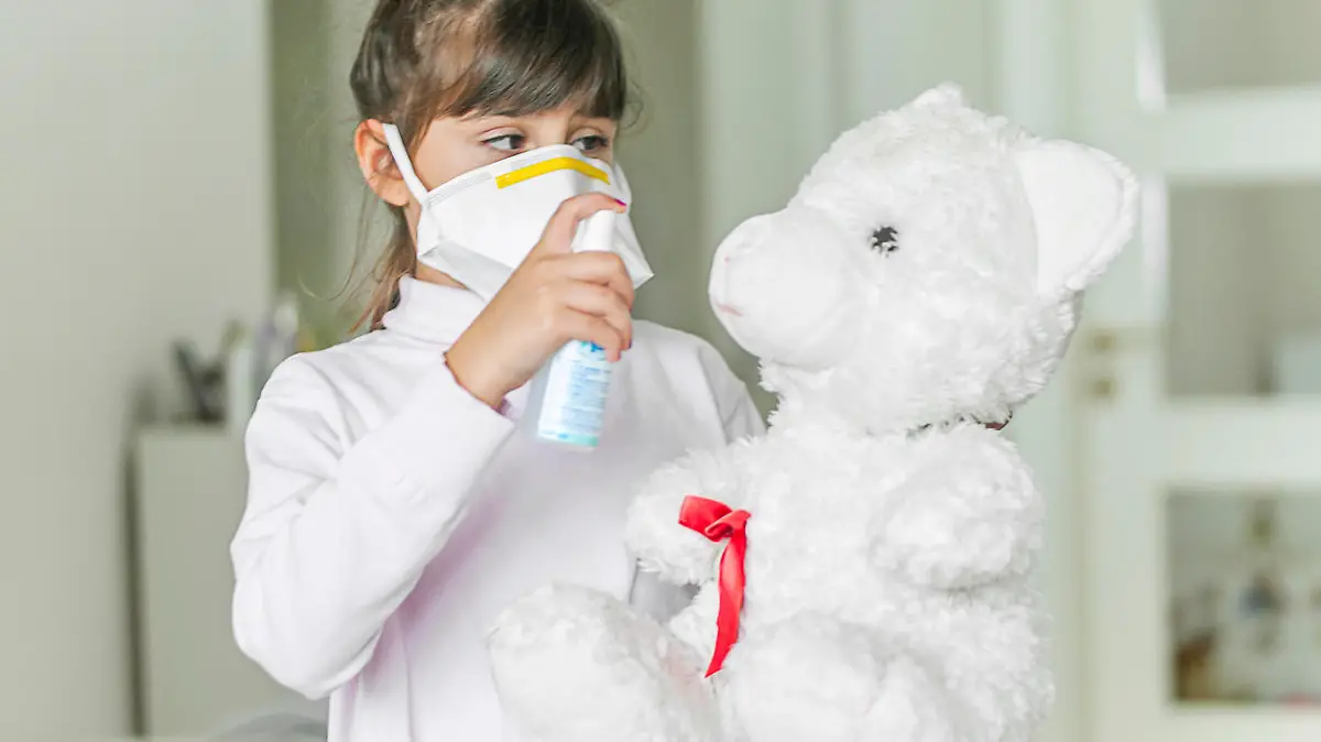 Kind desinfiziert einen Teddybär