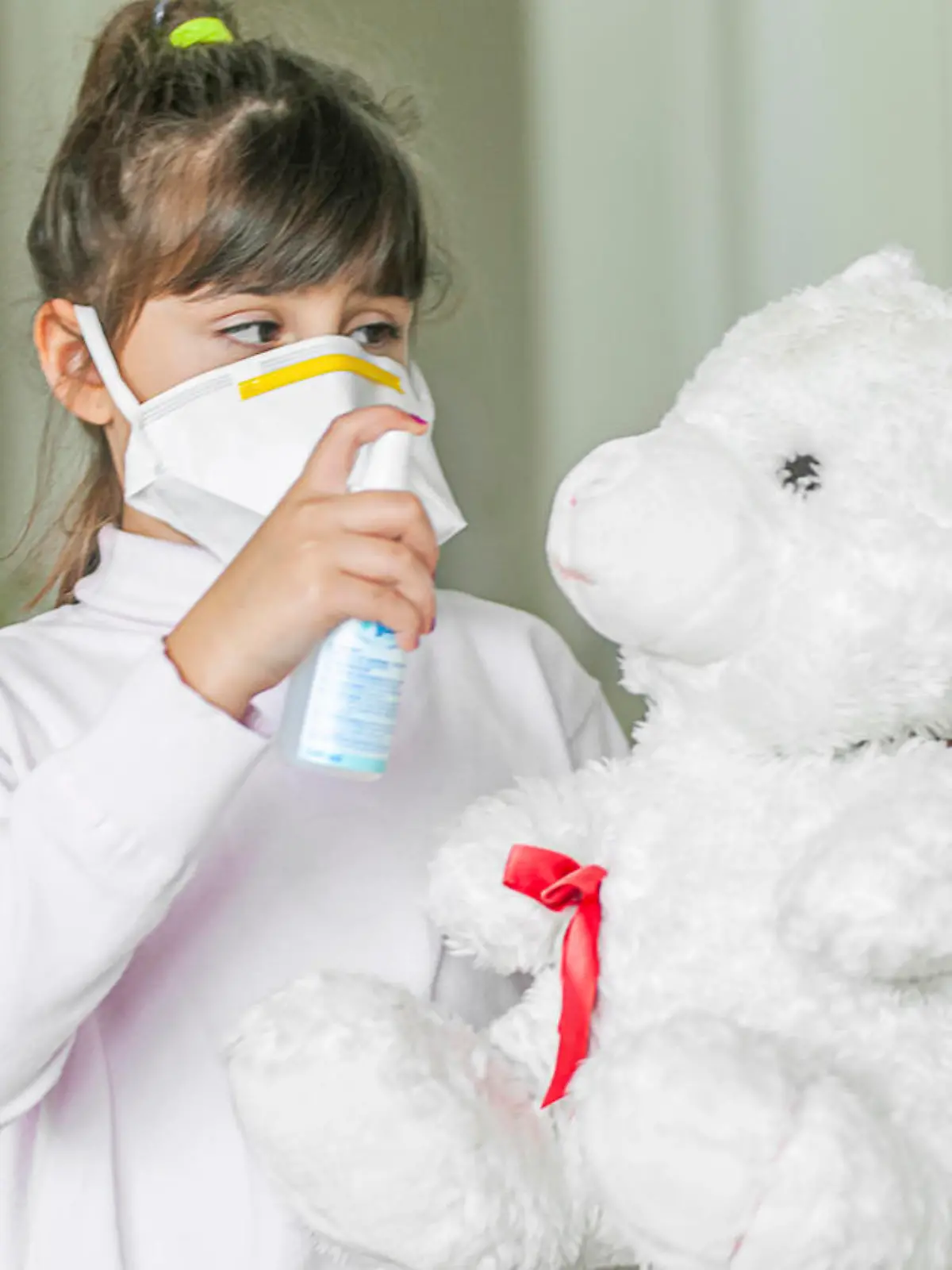 Kind desinfiziert einen Teddybär