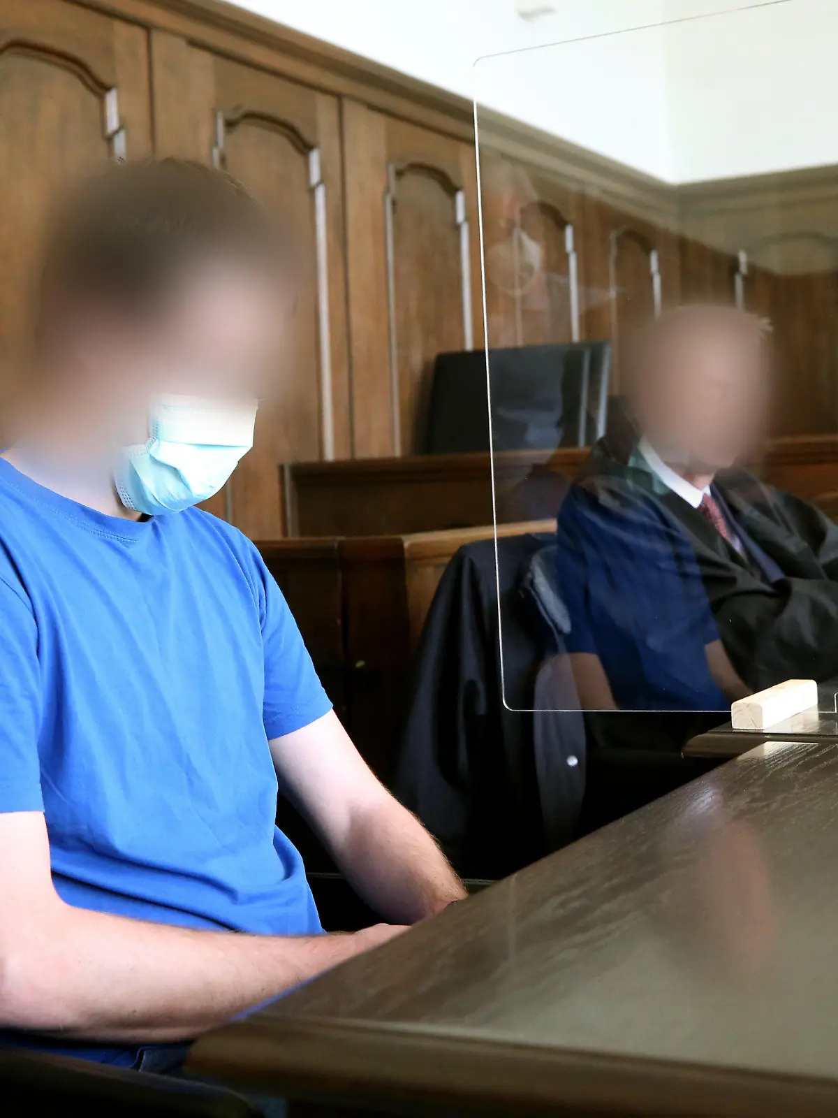 12.05.2020, Nordrhein-Westfalen, Moers: Der Angeklagte (l) und sein Anwalt warten auf den Beginn des Prozesses. Der 26 Jahre alte Soldat soll kleine Kinder in insgesamt 33 Fällen missbraucht haben, teilweise schwer und zwei Mal zusammen mit einem Chat-Partner. Foto: Roland Weihrauch/dpa Pool/dpa - ACHTUNG: Person(en) wurde(n) aus rechtlichen Gründen gepixelt +++ dpa-Bildfunk +++