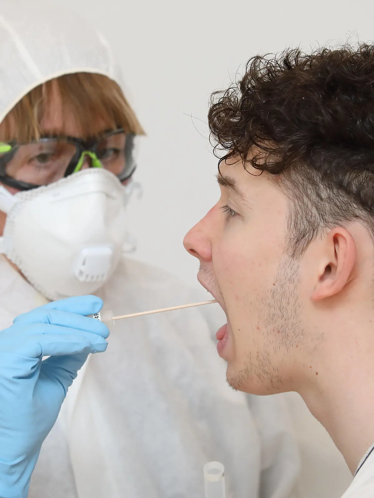  28.03.2020, Berlin, GER - Gestellte Szene: Junger Mann unterzieht sich einem Coronavirus-Test. MRyes, 20-30 Jahre, 40-50 Jahre, Abstrich, Aerztin, Alltag, Atemmaske, Berlin, Corona-Schnelltest, Corona-Test, Coronaepidemie, Coronainfektion, Coronapandemie, Coronavirus, Coronavirus-Schnelltest, Coronavirus-Test, Covid 19, Covid-19, deutsch, Deutschland, Europa, europaeisch, Frau, Freisteller, gestellte Szene, Infektion, Infektionsschutz, innen, Innenaufnahme, Kaukasier, kaukasisch, Mann, Menschen, Mundschutz, Patient, Personen, Probeentnahme, QF, Querformat, Schutzkleidung, Studio, Studioaufnahme, testen, Testroehrchen, Wattestaebchen, Westeuropa, Wirtschaft 200328D057BERLIN.JPG *** 28 03 2020, Berlin, GER Gestellte Szene Junger Mann undergoes a coronavirus test MR yes, 20 30 years, 40 50 years, smear, doctor, everyday life, breathing m