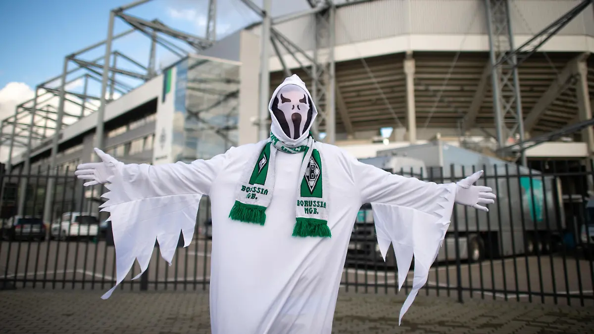 ARCHIV - 11.03.2020, Nordrhein-Westfalen, Mönchengladbach: Fußball: Bundesliga, 11. Spieltag, Borussia Mönchengladbach - 1. FC Köln im Borussia-Park. Ein als Geist verkleideter Gladbach-Fan steht vor dem Spiel am Stadion. (zu dpa-KORR Bundesliga-Kaltstart mit Risiken - Flick: «Jeder fängt bei Null an») Foto: Jonas Güttler/dpa - WICHTIGER HINWEIS: Gemäß den Vorgaben der DFL Deutsche Fußball Liga bzw. des DFB Deutscher Fußball-Bund ist es untersagt, in dem Stadion und/oder vom Spiel angefertigte Fotoaufnahmen in Form von Sequenzbildern und/oder videoähnlichen Fotostrecken zu verwerten bzw. verwerten zu lassen. +++ dpa-Bildfunk +++