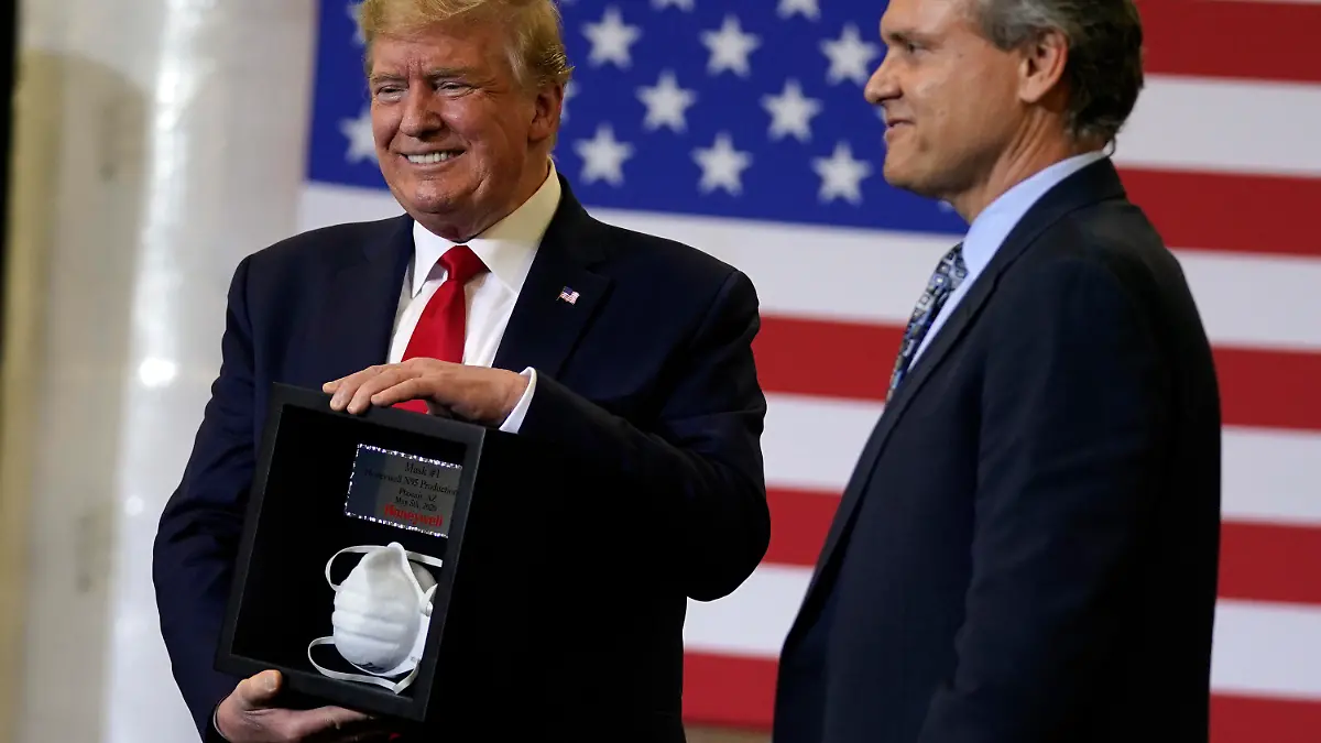 05.05.2020, USA, Phoenix: Darius Adamczyk (r), Vorstandsvorsitzender von Honeywell, überreicht Donald Trump, Präsident der USA, eine gerahmte Atemschutzmaske von Typ N95, nach einem Rundgang durch ein Werk von Honeywell International, das Schutzausrüstungen herstellt. Foto: Evan Vucci/AP/dpa +++ dpa-Bildfunk +++