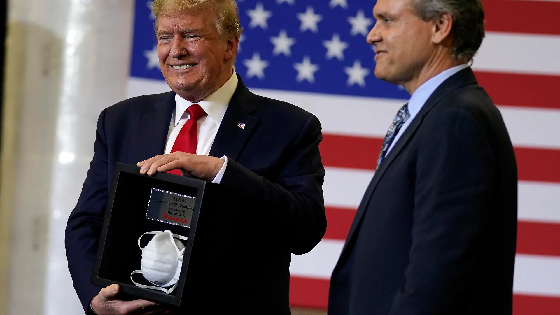 05.05.2020, USA, Phoenix: Darius Adamczyk (r), Vorstandsvorsitzender von Honeywell, überreicht Donald Trump, Präsident der USA, eine gerahmte Atemschutzmaske von Typ N95, nach einem Rundgang durch ein Werk von Honeywell International, das Schutzausrüstungen herstellt. Foto: Evan Vucci/AP/dpa +++ dpa-Bildfunk +++