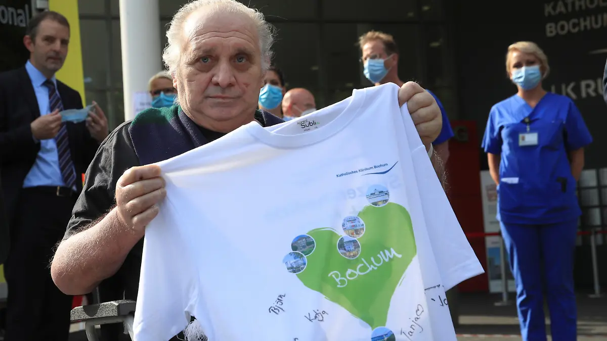 Claudio Facoetti, a 65-year-old man from the northern Italian city of Bergamo, near Milan, holds a T-shirt signed by the intensive care nurses of the Saint Josef university clinic after he recovered within six weeks from the coronavirus disease (COVID-19) in Bochum, Germany, May 9, 2020. REUTERS/Wolfgang Rattay
