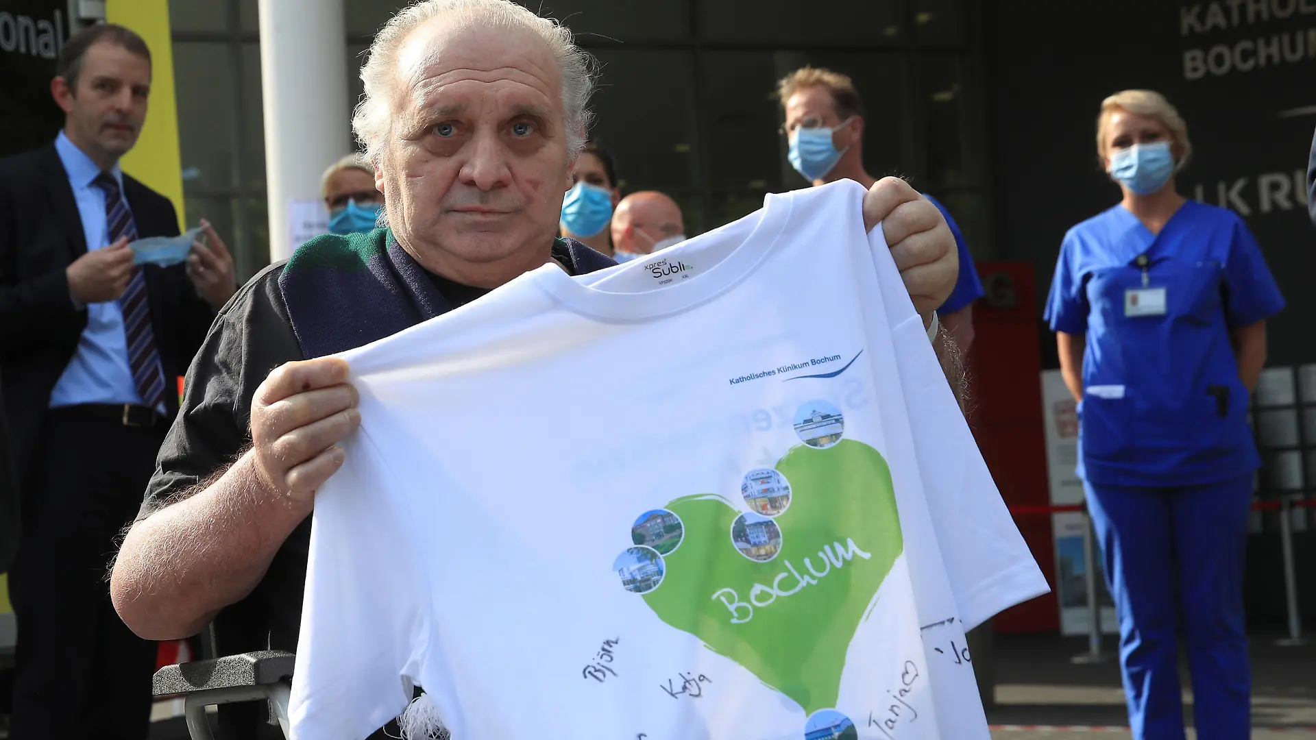 Claudio Facoetti, a 65-year-old man from the northern Italian city of Bergamo, near Milan, holds a T-shirt signed by the intensive care nurses of the Saint Josef university clinic after he recovered within six weeks from the coronavirus disease (COVID-19) in Bochum, Germany, May 9, 2020. REUTERS/Wolfgang Rattay