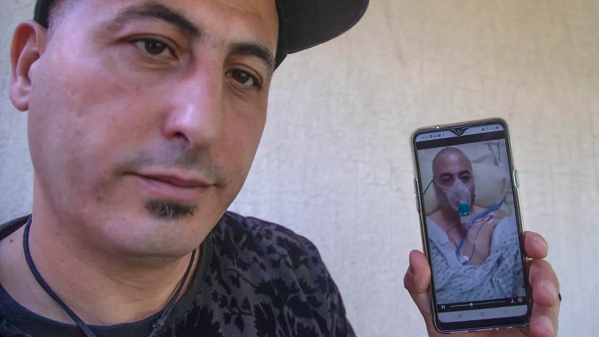 Amirouche Hammar show his picture taken at the hospital on his mobile phone during an interview with The Associated-Press in Bobiny, east of Paris, Wednesday, May 6, 2020. In a study published in the International Journal of Microbial Agents, doctors at a hospital north of Paris reviewed retrospective samples of 14 patients treated for atypical pneumonia between early December and mid-January. Among those were the records of Amirouche Hammar, a 42-year-old fishmonger from Algeria who has lived in France for years and had no recent travel history. (AP Photo/Michel Euler)